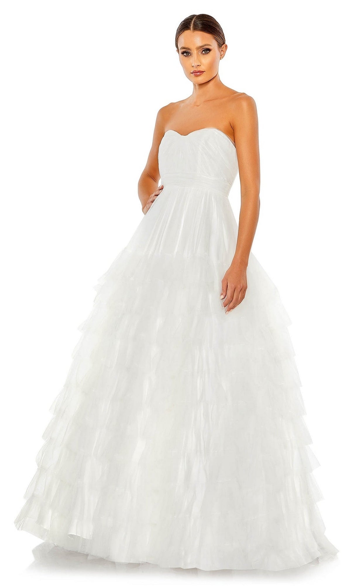 A woman stands facing forward against a white background in the Long Formal Dress 67999 by Mac Duggal, featuring a strapless bodice, empire waist, and layered tulle skirt.