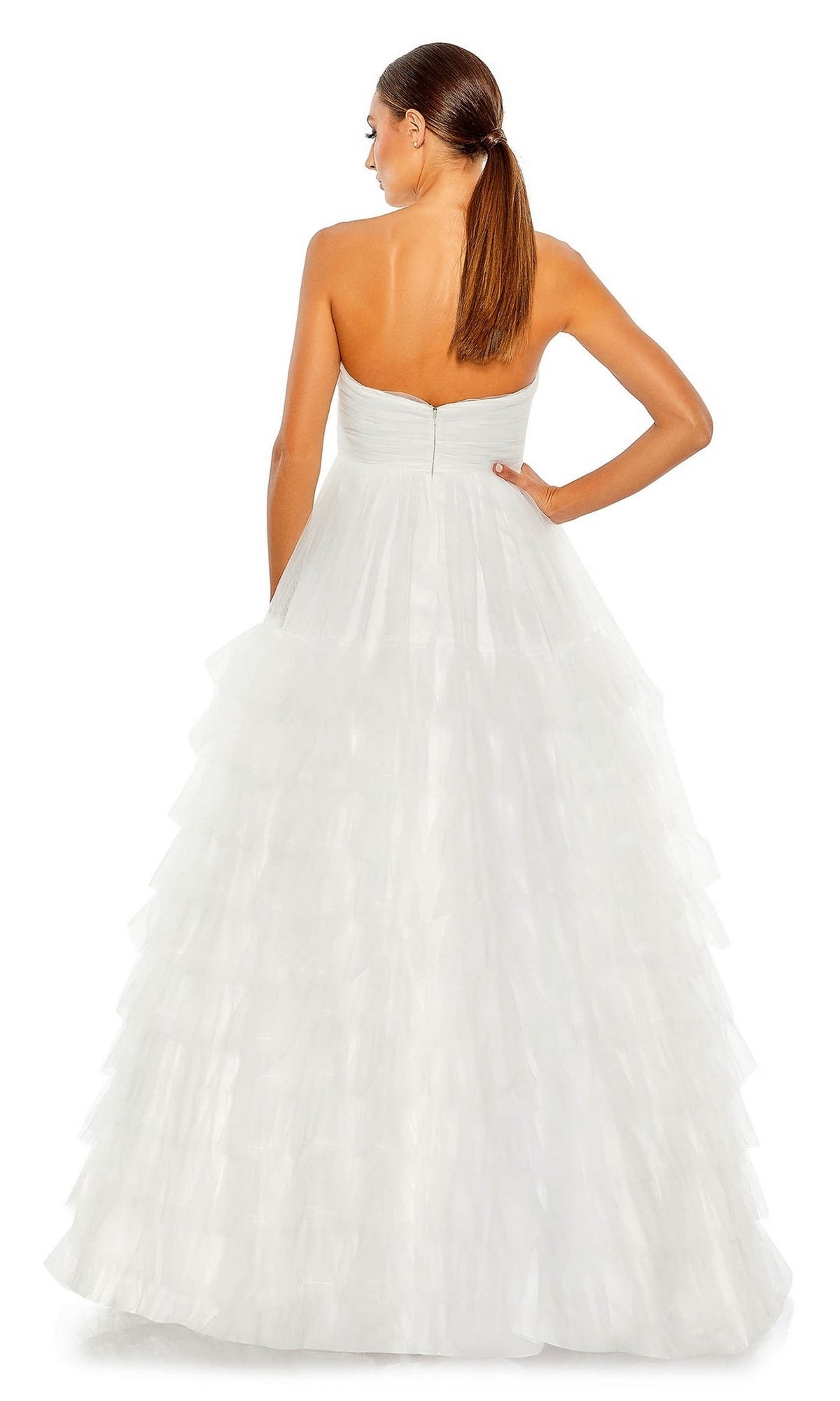 A woman faces away, showcasing the elegant back of the Long Formal Dress 67999 by Mac Duggal—a strapless ball gown with an empire waist and layered tulle skirt.