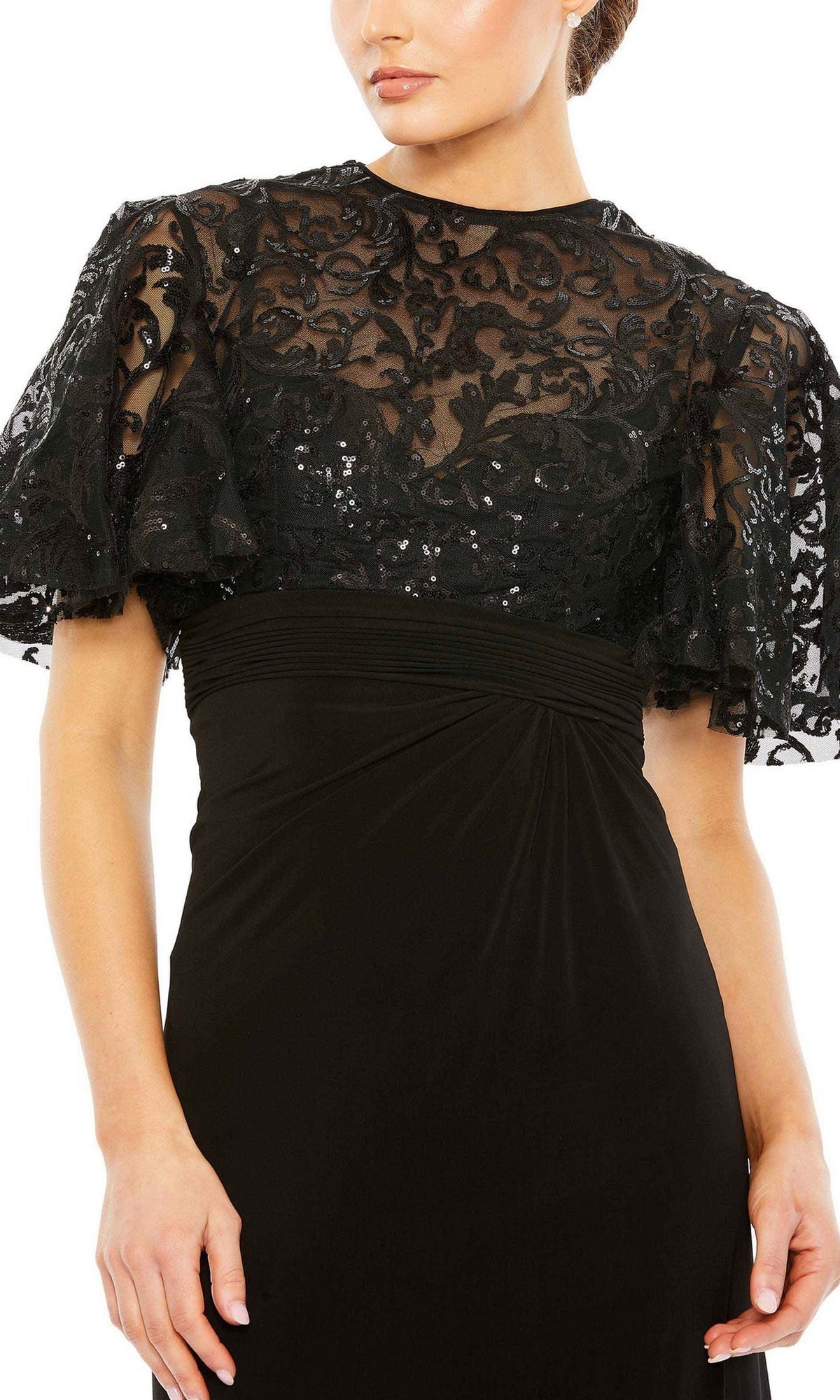 Woman wearing the Mac Duggal 68002 short sleeve black formal dress, featuring a sheer lace bodice overlay and elegant sequin-lace sleeves with ruffled details.