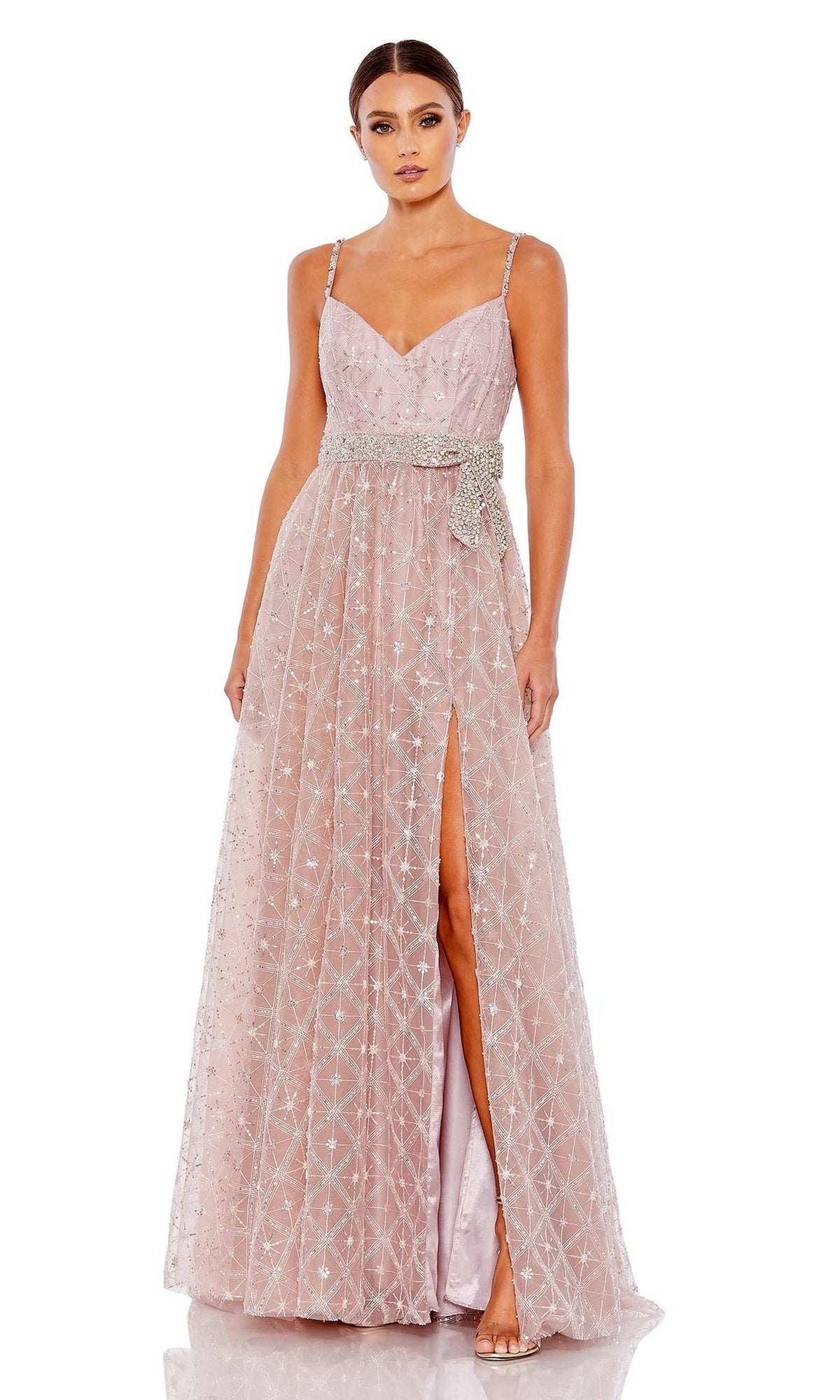A woman wearing the Long Formal Dress 68050 by Mac Duggal in rose pink, featuring a sleeveless geometric sequin design, thin straps, high slit, and an embellished bow at the waist.