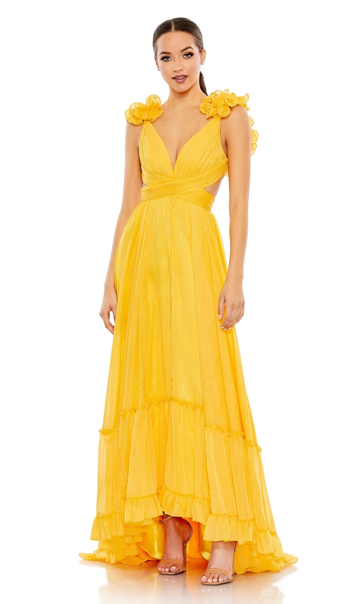 Woman wearing the Mac Duggal 68094 Lace-Up Ruffled Formal Gown, a sleeveless yellow maxi dress with floral shoulder accents, deep V-neckline, and layered ruffle hem, standing against a plain white background.