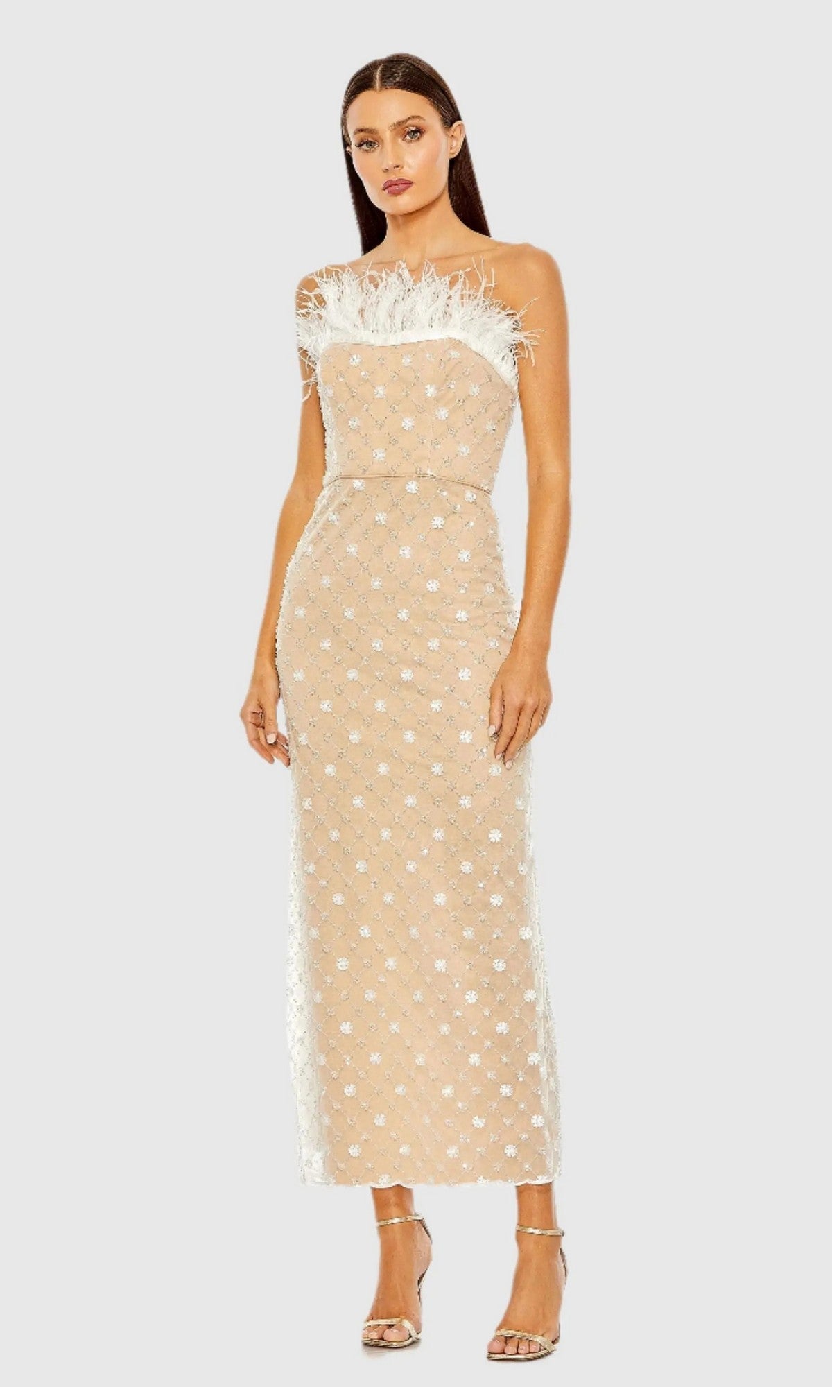 A woman wearing the Mac Duggal 68140V Tea-Length Party Dress in Ivory Nude, featuring a strapless silhouette with white floral embroidery and feather trim, stands against a plain light background.
