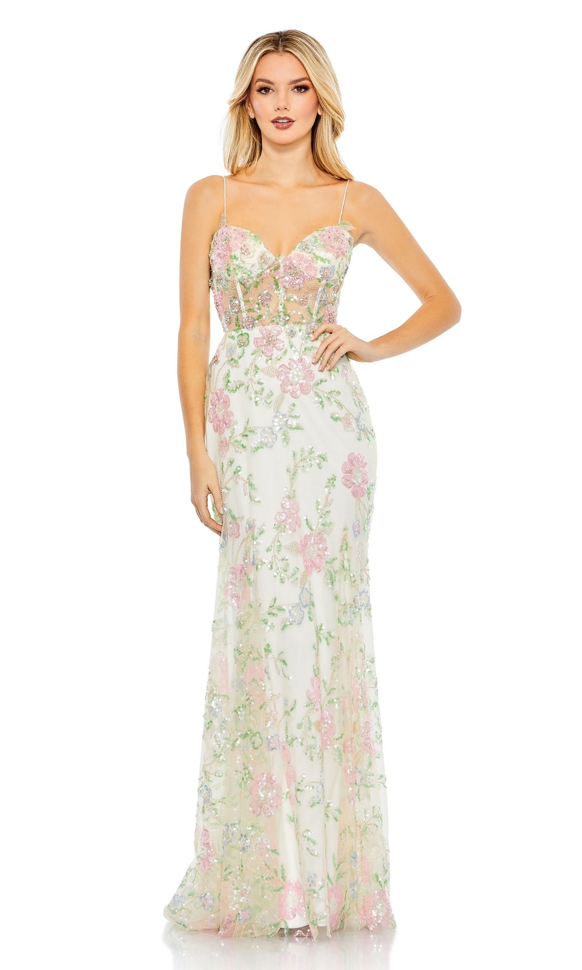 A woman wears the Long Formal Dress 68180 by Mac Duggal, a fitted floral gown with pink and green patterns, a sheer corset bodice, and thin spaghetti straps for an elegant look.