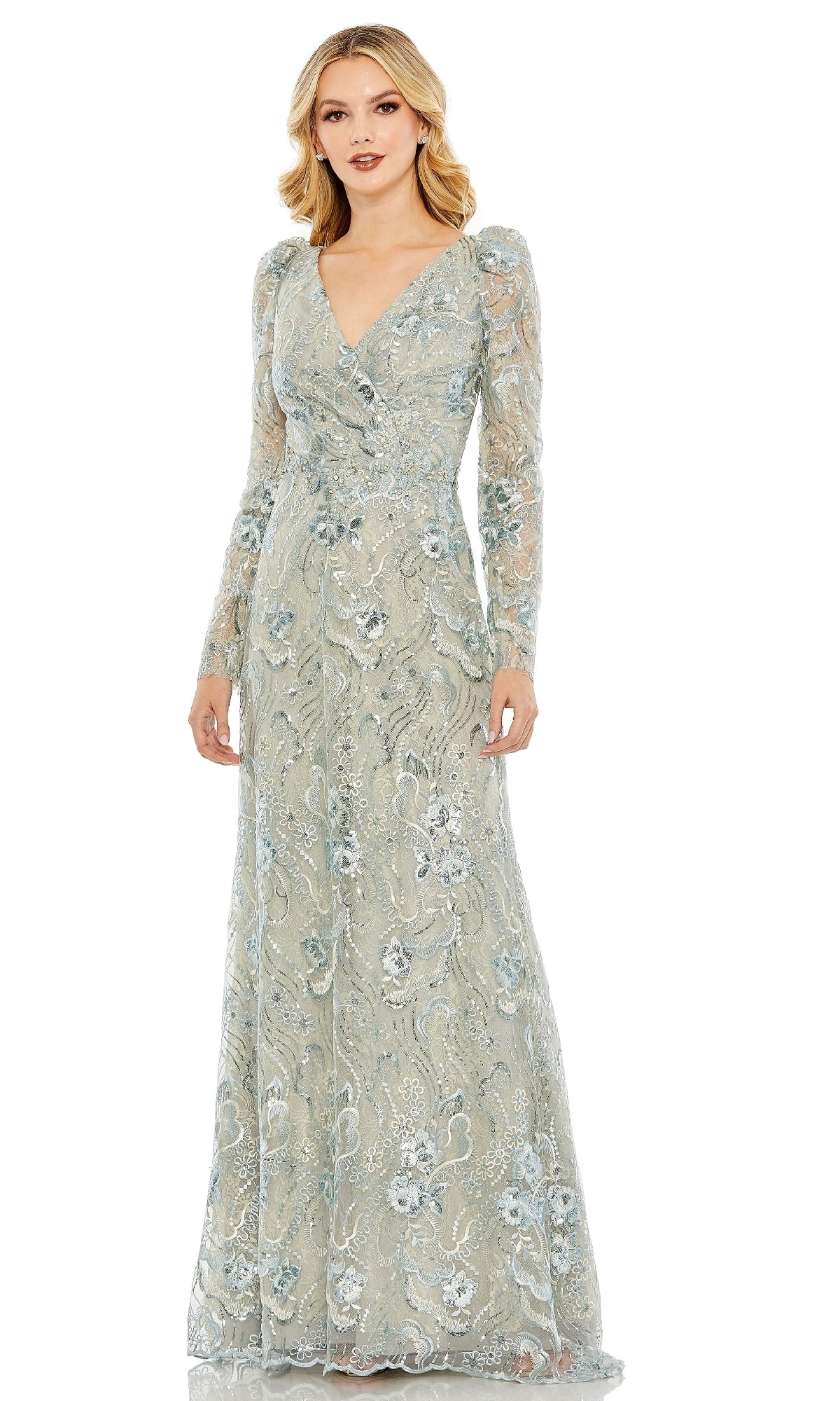 A woman in the Mac Duggal 68190 Long Sleeve Beaded Formal Dress stands against a white background, showcasing its elegant light blue lace, floral embroidery, and long sleeves.