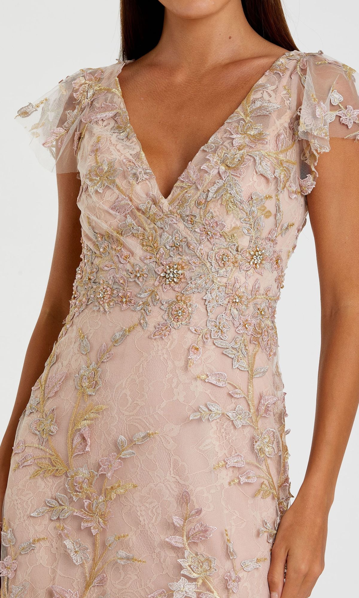 A woman wearing the Mac Duggal 68192 long beaded formal dress, featuring light pink lace, floral embroidery, short flutter sleeves, and a deep V neckline.
