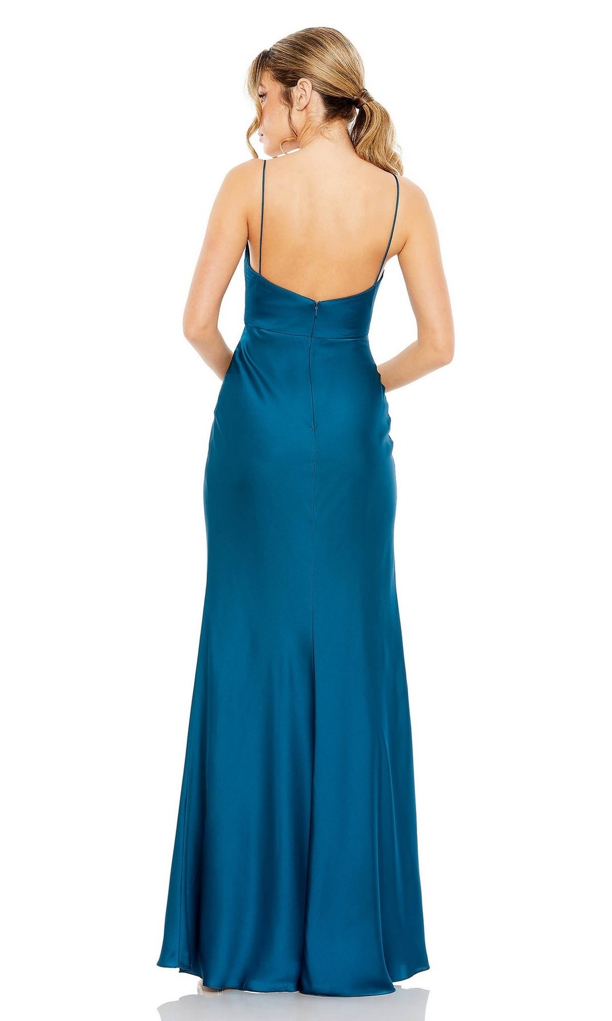 Woman with a ponytail wears the Mac Duggal 68347 Cut-Out Long Formal Dress—a floor-length teal satin gown with thin straps, twist-front bodice, and backless design—standing and facing away from the camera.