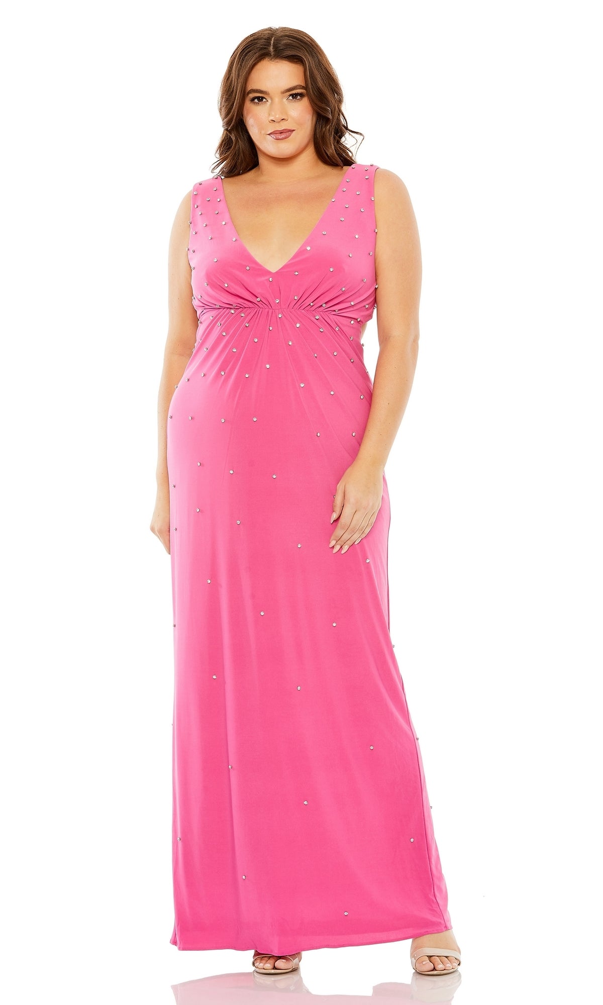 A woman stands facing forward in the Long Plus-Size Formal Dress 68353 by Mac Duggal, a sleeveless, floor-length hot pink gown featuring a V-neckline and subtle embellishments.