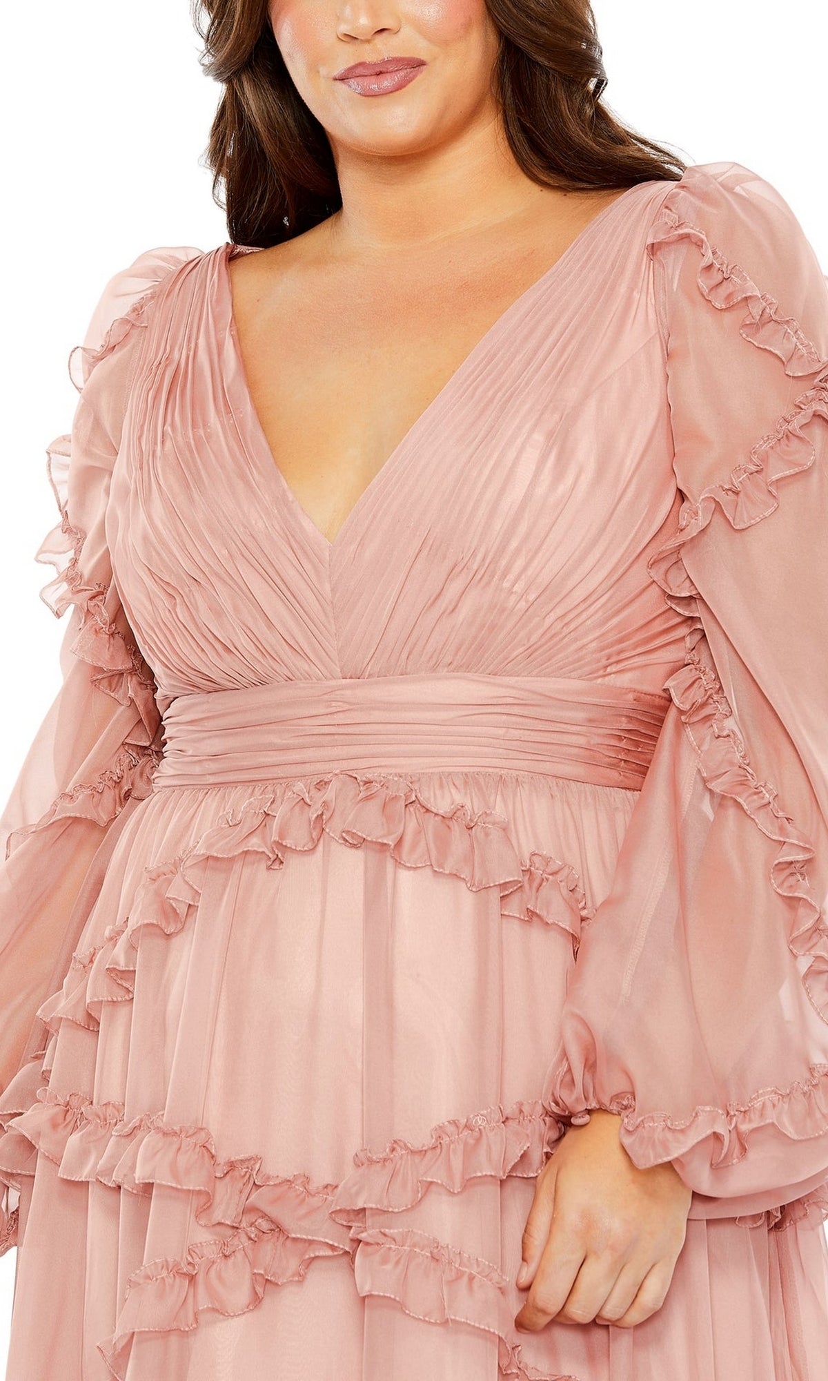 A person wearing the Mac Duggal Long Plus-Size Prom Dress 68425 in blush pink, styled with long ruffled sleeves and a deep V-neckline.