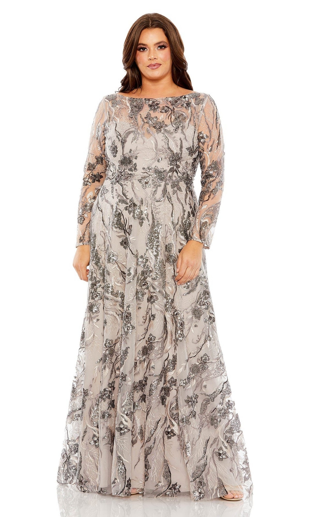A woman faces forward against a white background wearing the Long Plus-Size Prom Dress 68439 by Mac Duggal—an embroidered, silver-gray A-line gown with floral sequin details and a sheer illusion bodice.