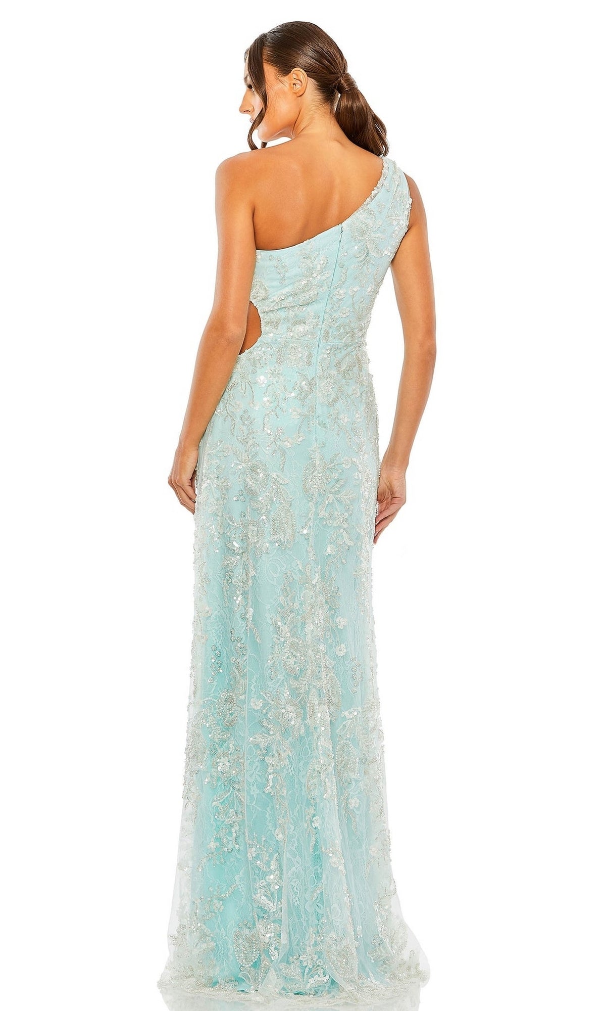 A woman with brown hair in a low ponytail is seen from the back wearing the Long Formal Dress 68507 by Mac Duggal, a light blue, one-shoulder gown with floral embroidery and a flowing, floor-length silhouette.