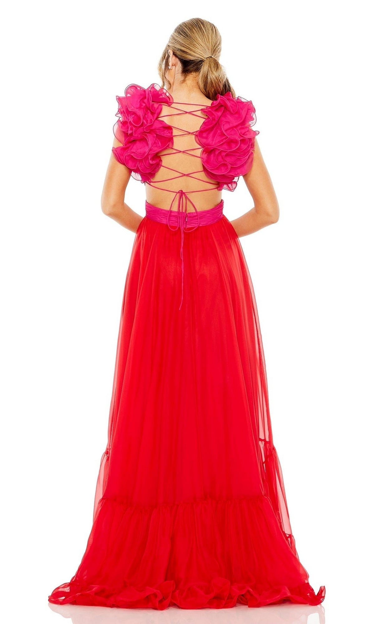 A woman stands facing away, wearing the Long Formal Dress 68522 by Mac Duggal—a bright pink tiered dress with shoulder ruffles and an open back with crisscross laces.