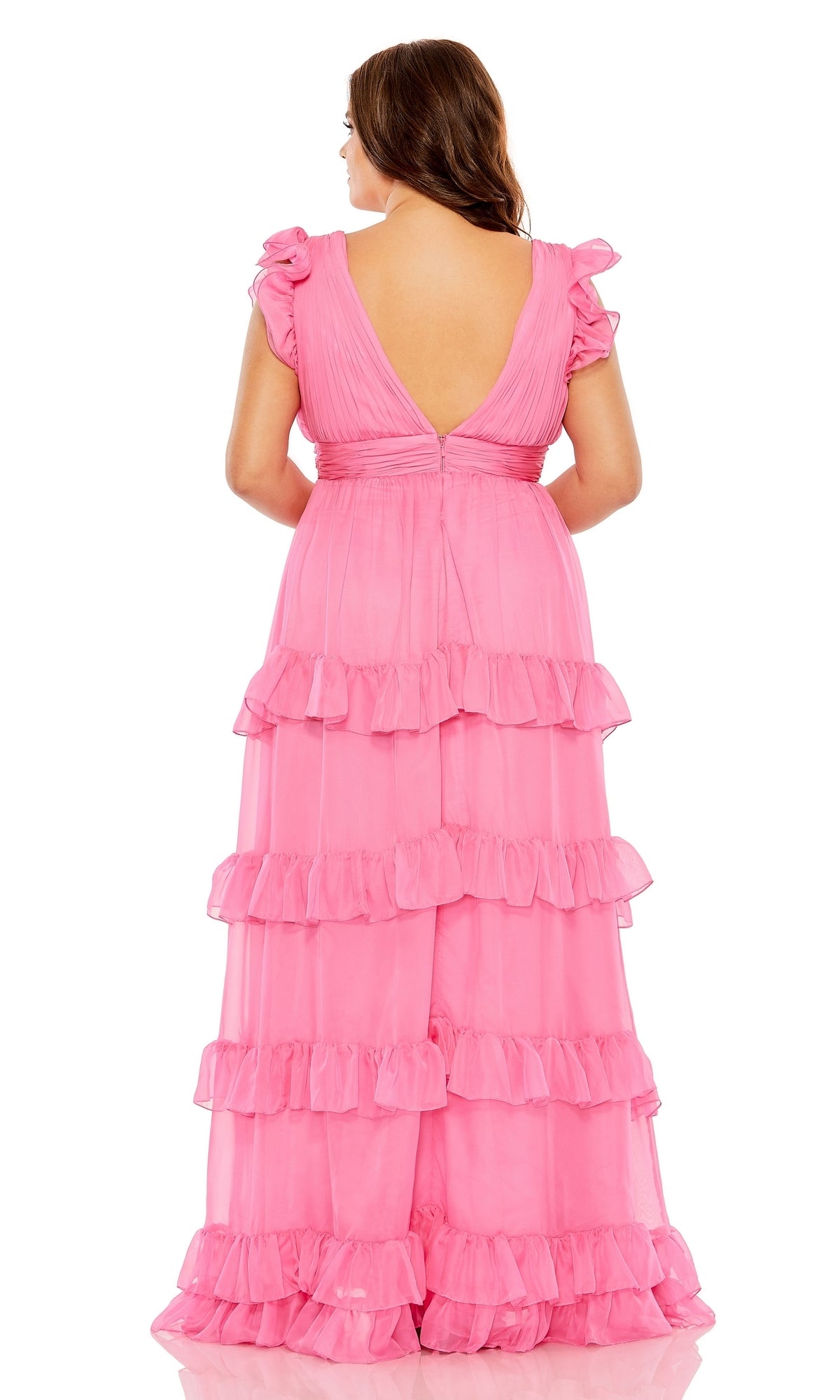A woman faces away, wearing the Long Plus-Size Formal Dress 68544 by Mac Duggal—a stunning pink gown with layered floor-length ruffles and a deep V-back design.