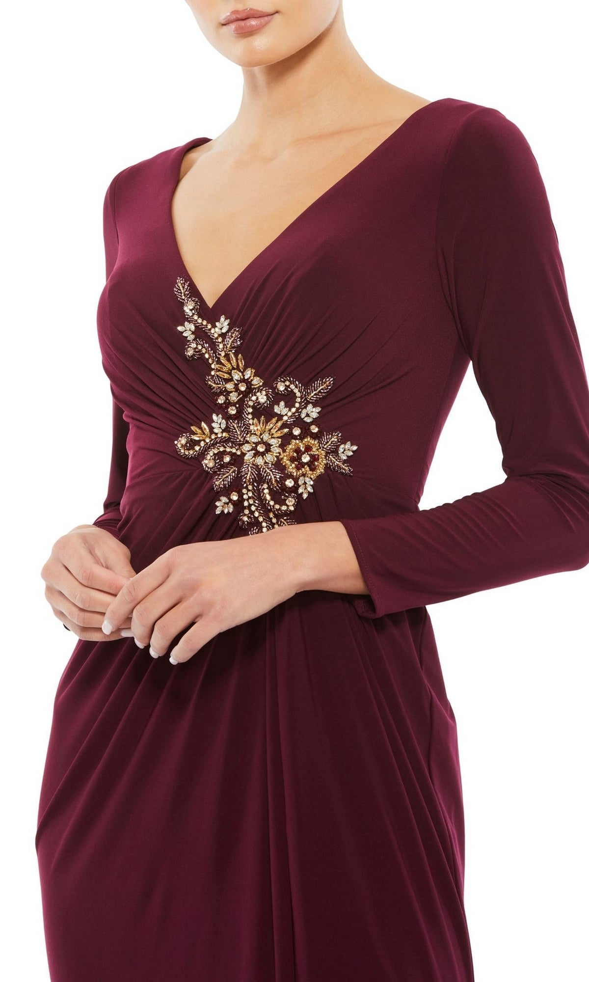 A woman wears the Long Formal Dress 68736 by Mac Duggal—deep burgundy, long and fitted, with a V-neckline and gold floral beaded applique detailing on the bodice.
