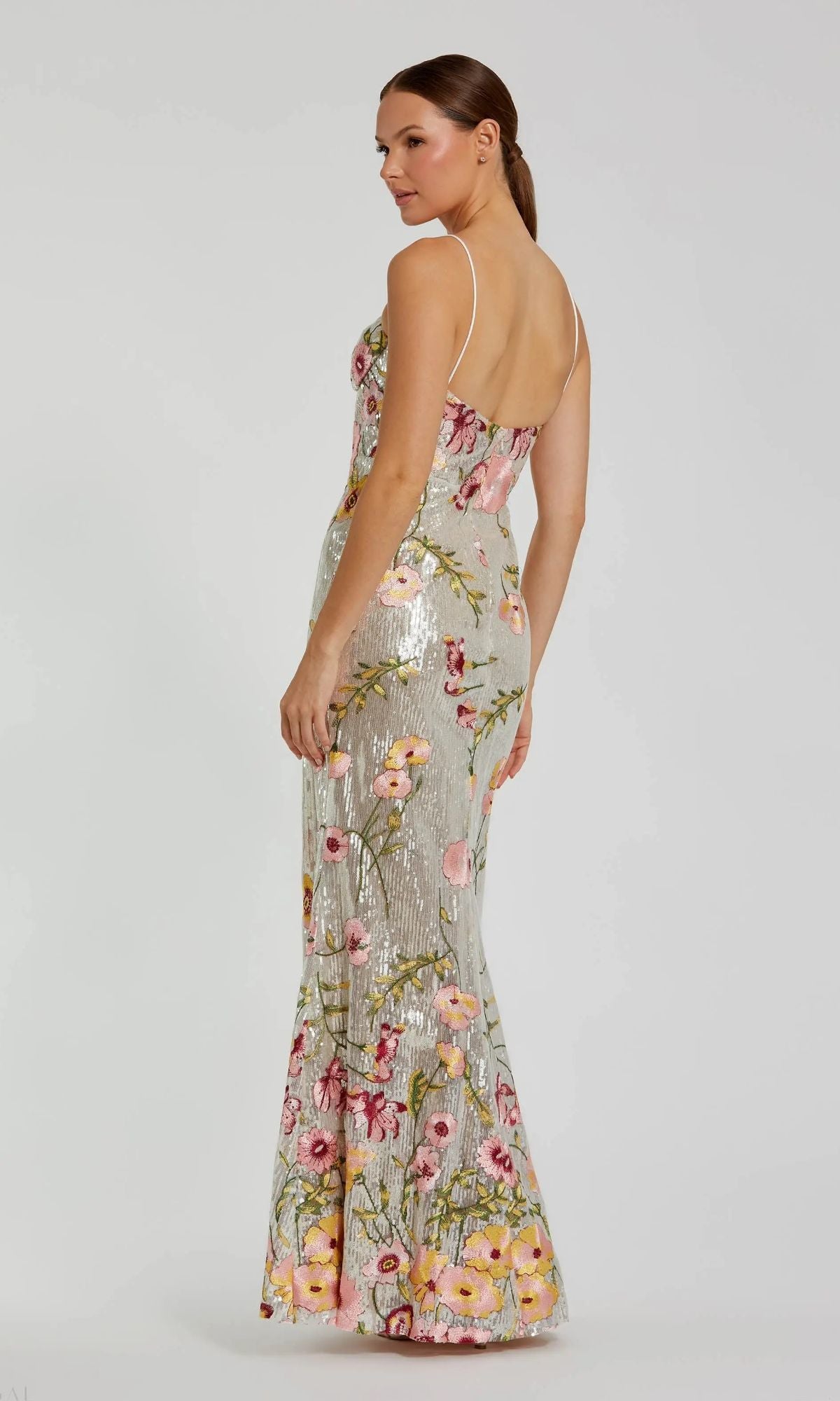 A woman models the Mac Duggal 68896 long formal dress—a floor-length, sleeveless sequin gown with thin straps and a floral pattern—on a plain white background.