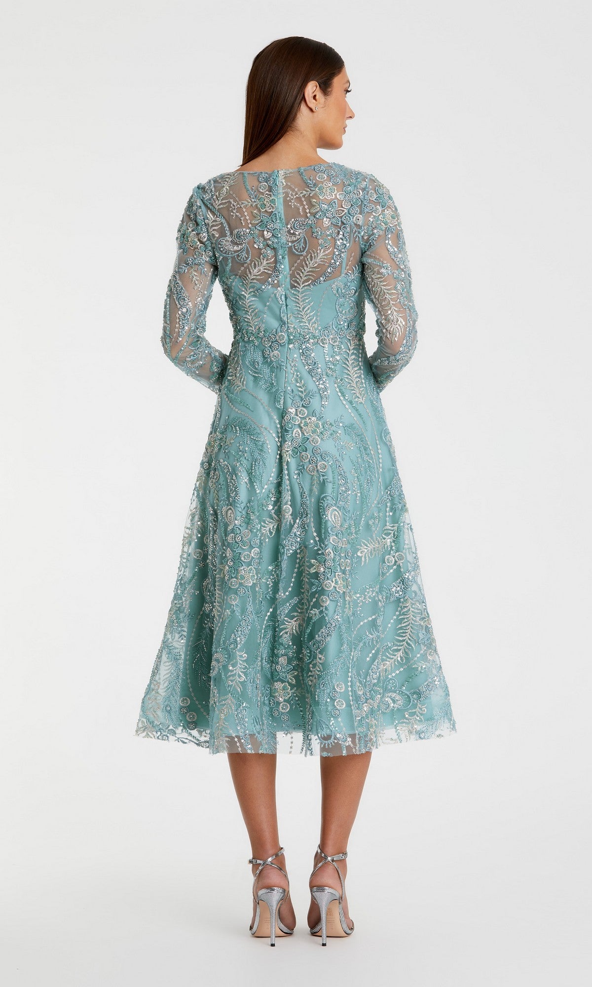 A woman stands in heels, seen from the back against a plain white background, wearing the Mac Duggal 68915 Midi Party Dress—a light blue, long-sleeved dress featuring floral embroidery and a graceful fit-and-flare midi silhouette.