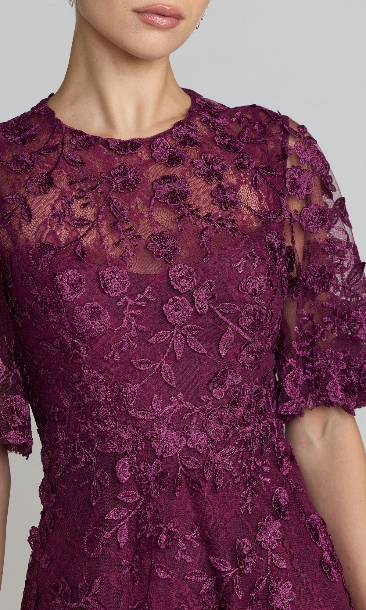 Woman in the Mac Duggal 69036 Lace Midi Wedding Guest Dress—burgundy short sleeve, sheer sleeves, floral embroidery, and high neckline. Perfect for attending weddings.