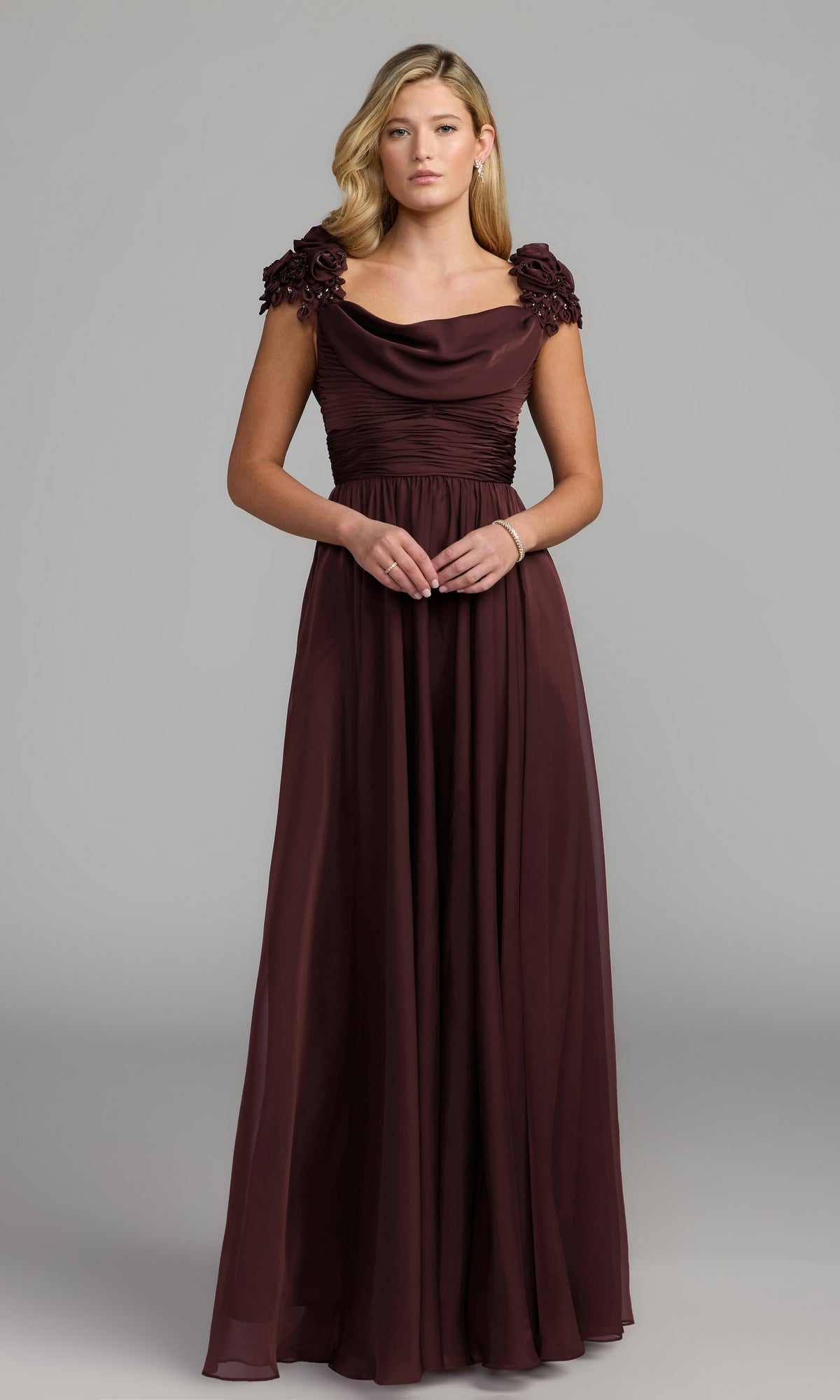 A woman stands against a plain gray background wearing the Long Formal Dress: Mac Duggal 69088 in amethyst, a floor-length gown featuring floral appliqué on the cap sleeves.