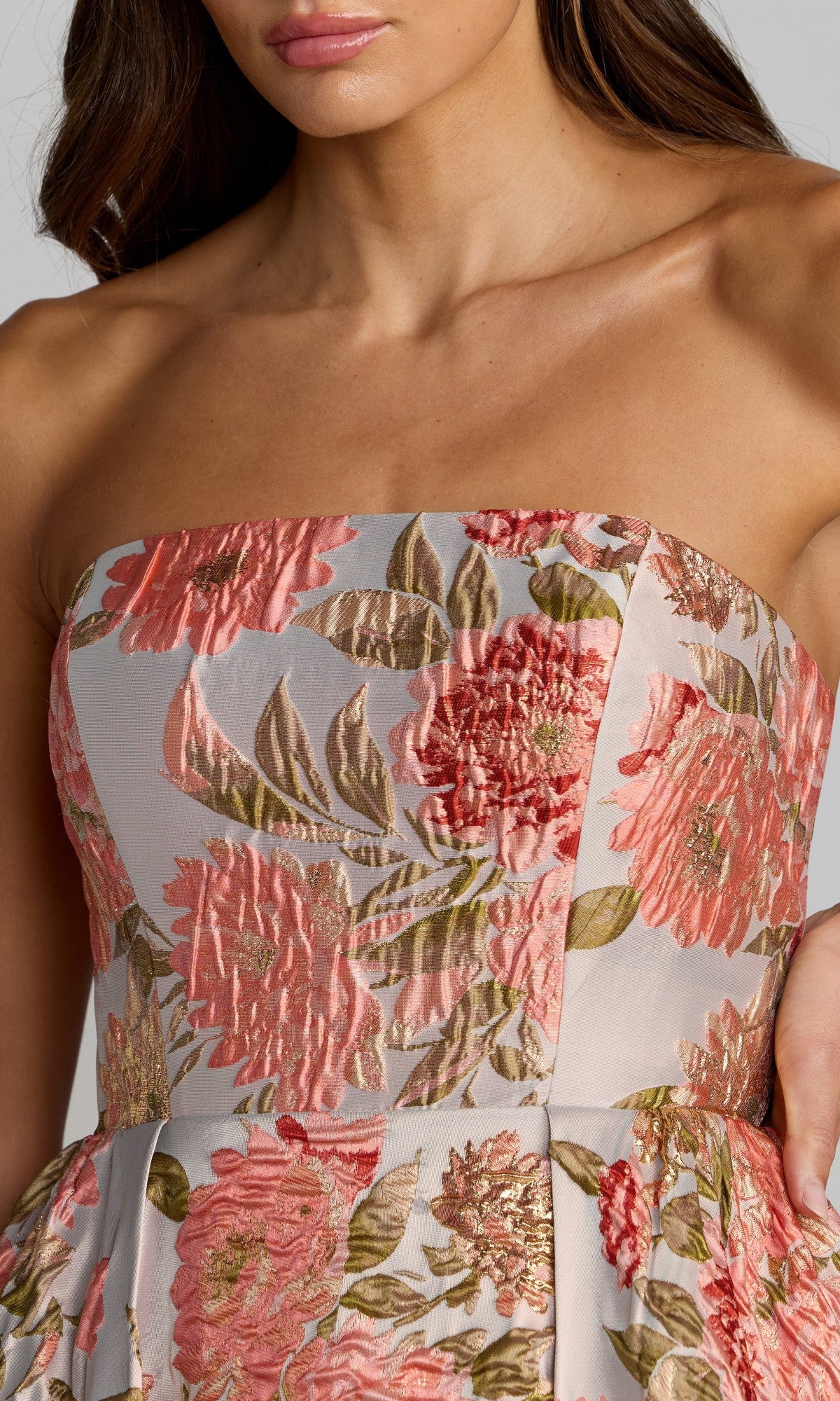 Woman wearing the Mac Duggal 69169 long formal dress, a strapless A-line style featuring a pink and gold floral-brocade pattern, shown from the shoulders to mid-torso.