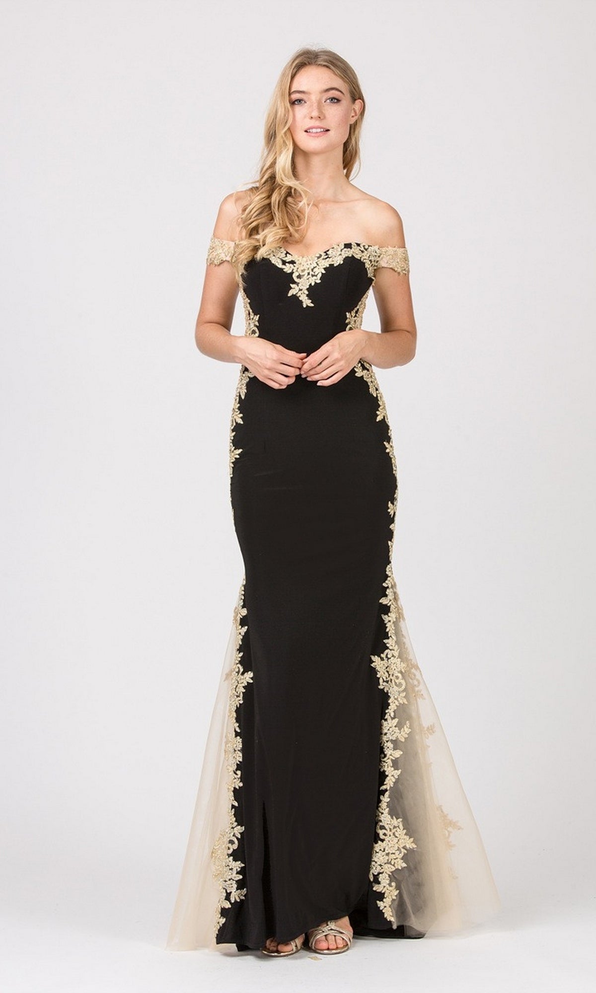 A woman wears the Long Formal Dress: Eureka 7006—black with gold metallic lace appliques—standing against a plain light background.