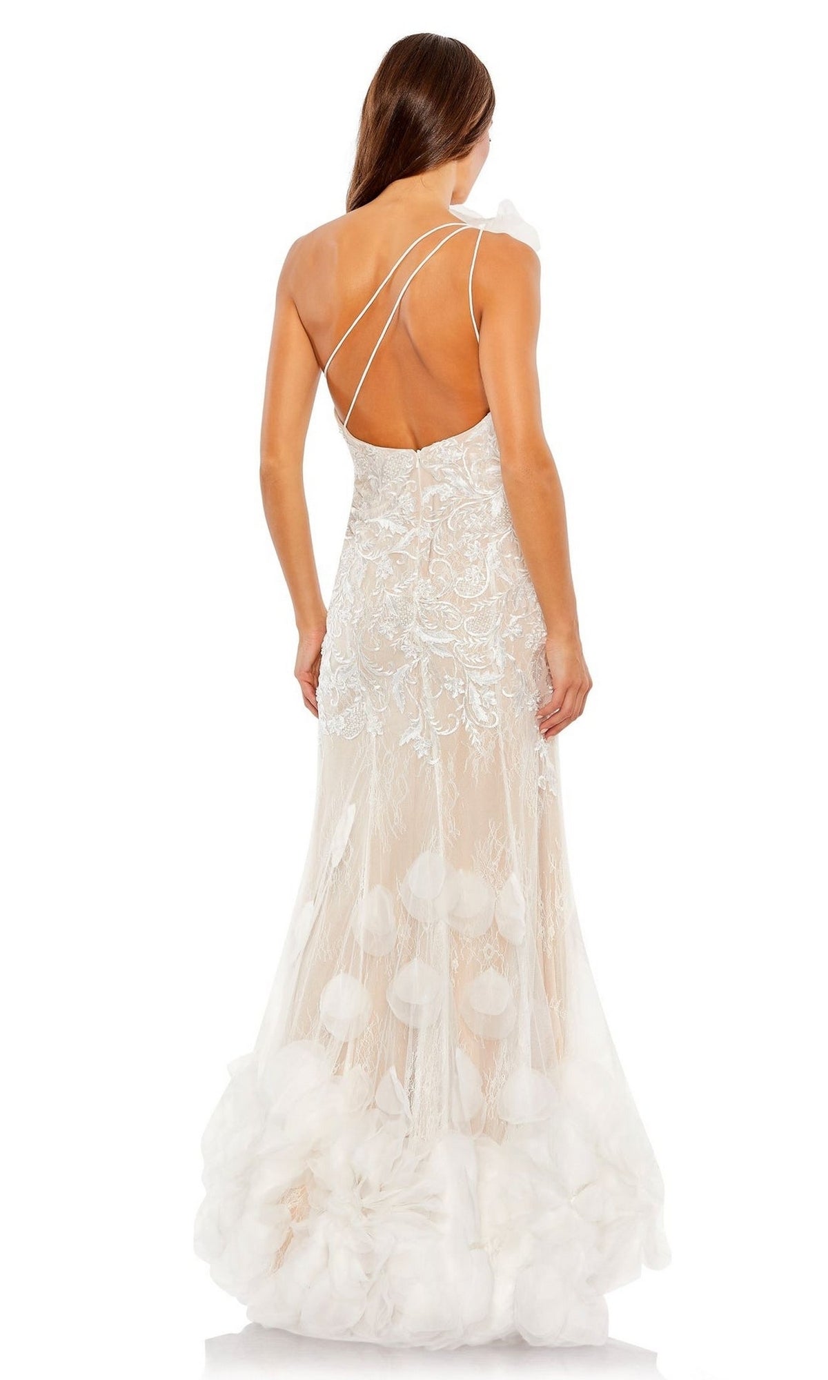 A woman faces away from the camera wearing the Long Formal Dress 70131 by Mac Duggal, a white one-shoulder mermaid gown with lace detailing, sheer panels, and elegant ruffle floral accents.
