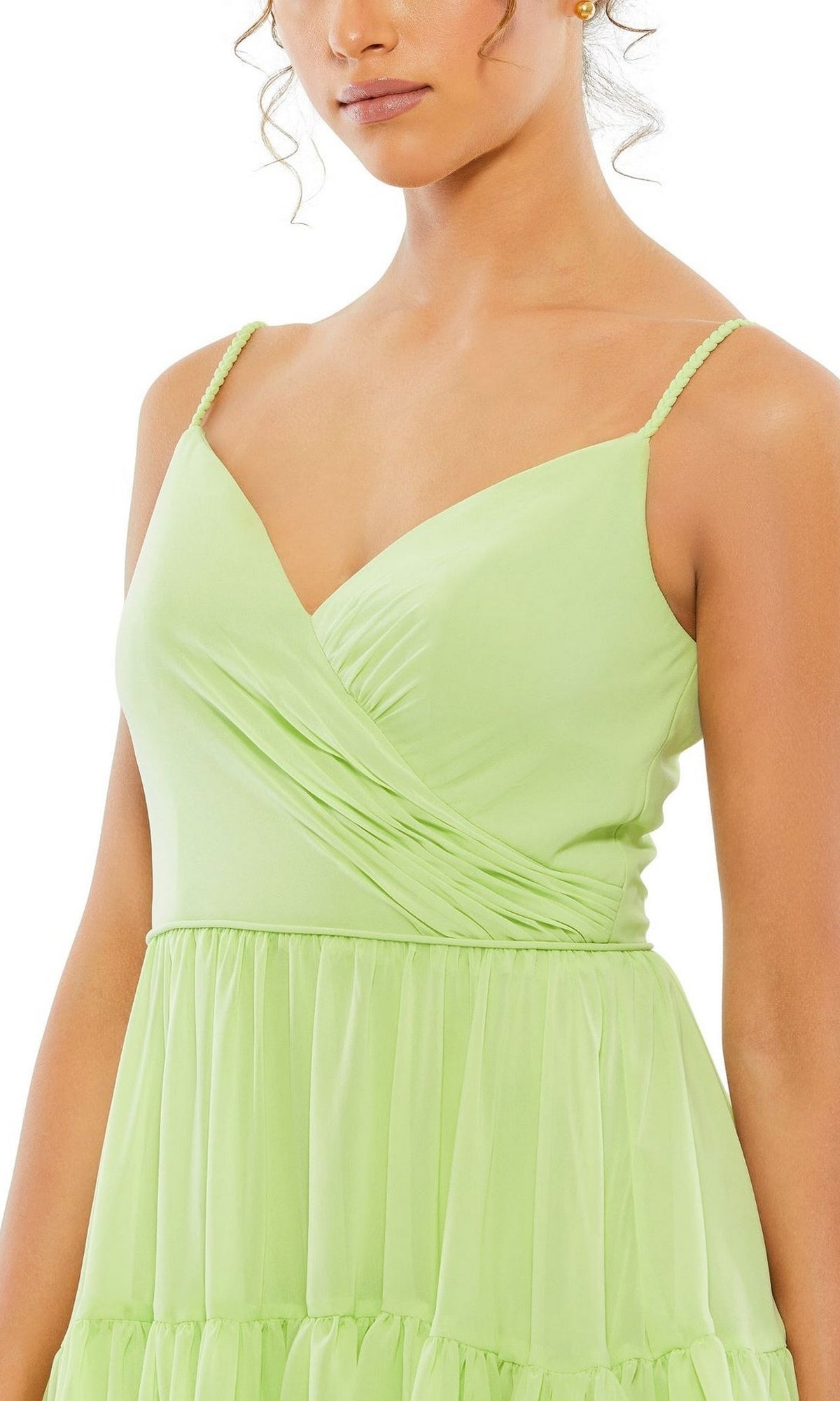 A woman wearing the Mac Duggal 70200 Short Tiered Wedding-Guest Dress in light green, featuring thin straps and a v-neckline, shown from the chest up.