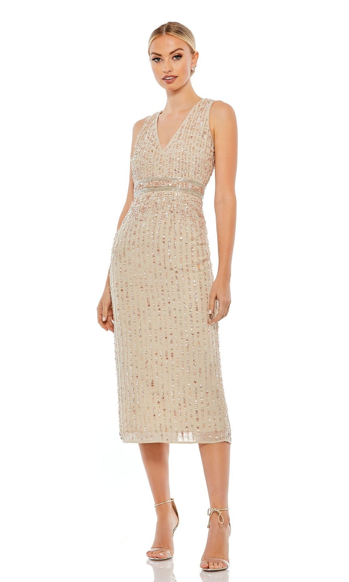 A woman in the Mac Duggal 70267 Beaded Midi Wedding-Guest Dress, featuring sparkly embellishments on a sleeveless beige silhouette, pairs it with neutral high-heeled sandals.