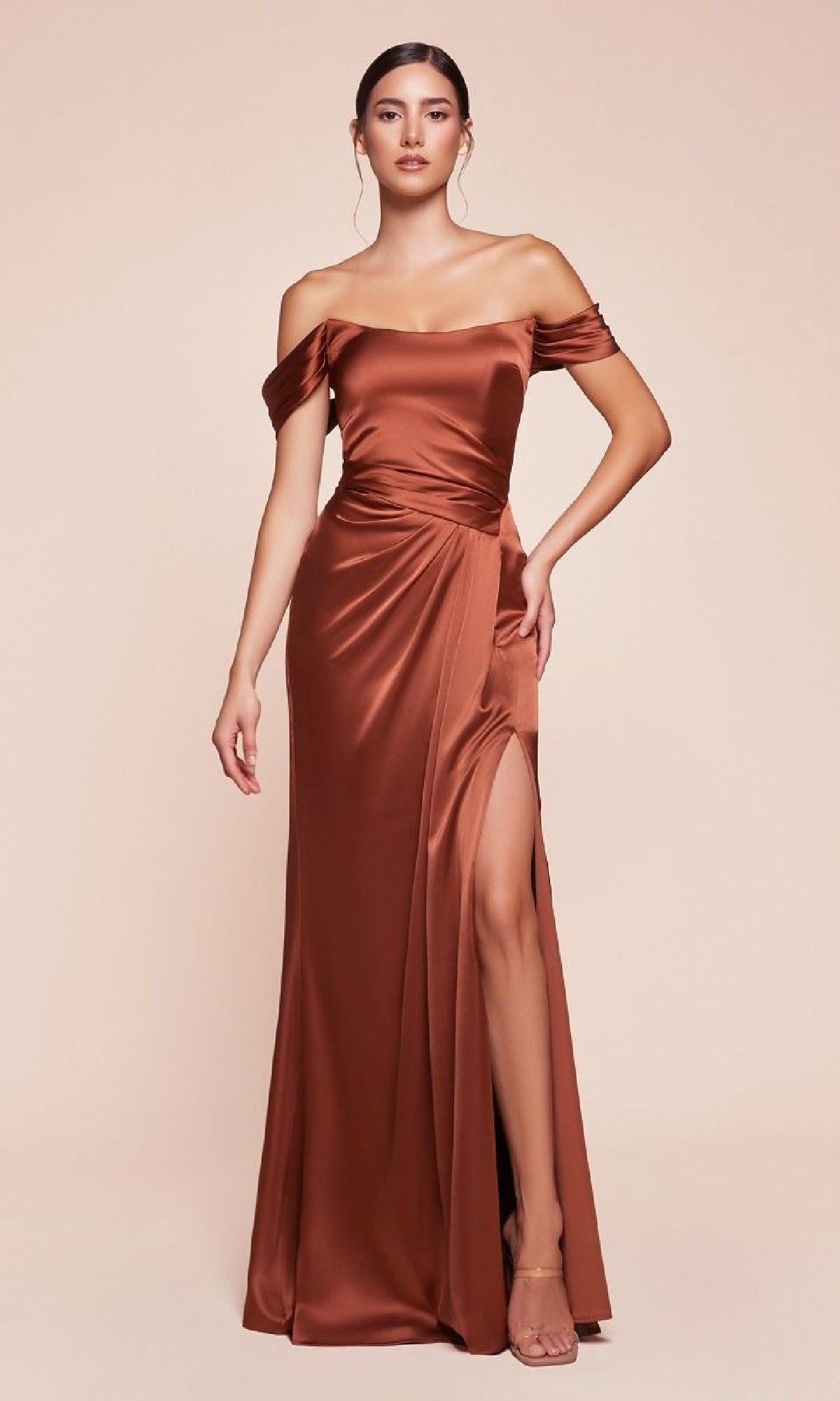 Woman models the Ladivine 7452 Lace-Up Off-Shoulder Prom Dress in rust satin, featuring a thigh-high slit, against a simple light backdrop.