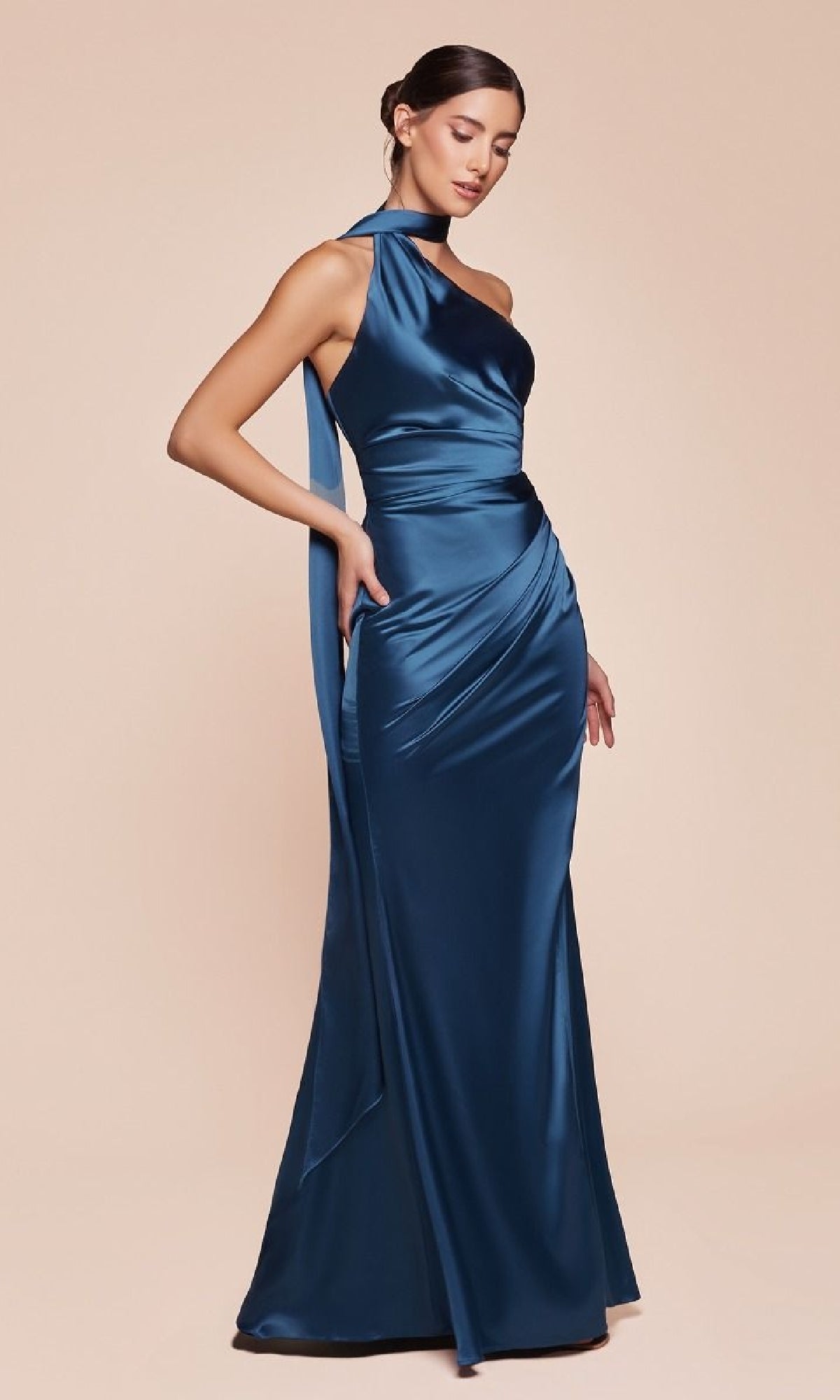 Model wearing the One-Shoulder Sash Long Prom Dress (Ladivine 7454) in blue, featuring a floor-length satin design with an asymmetrical neckline and scarf detail, set against a plain beige background.