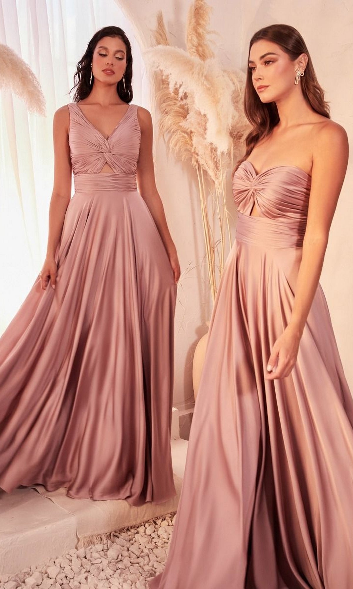 Two women wear the Twist-Front Long A-Line Cut-Out Prom Dress 7497, featuring affordable, floor-length mauve satin with ruched bodices and sleeveless design, standing indoors by pampas grass decor.