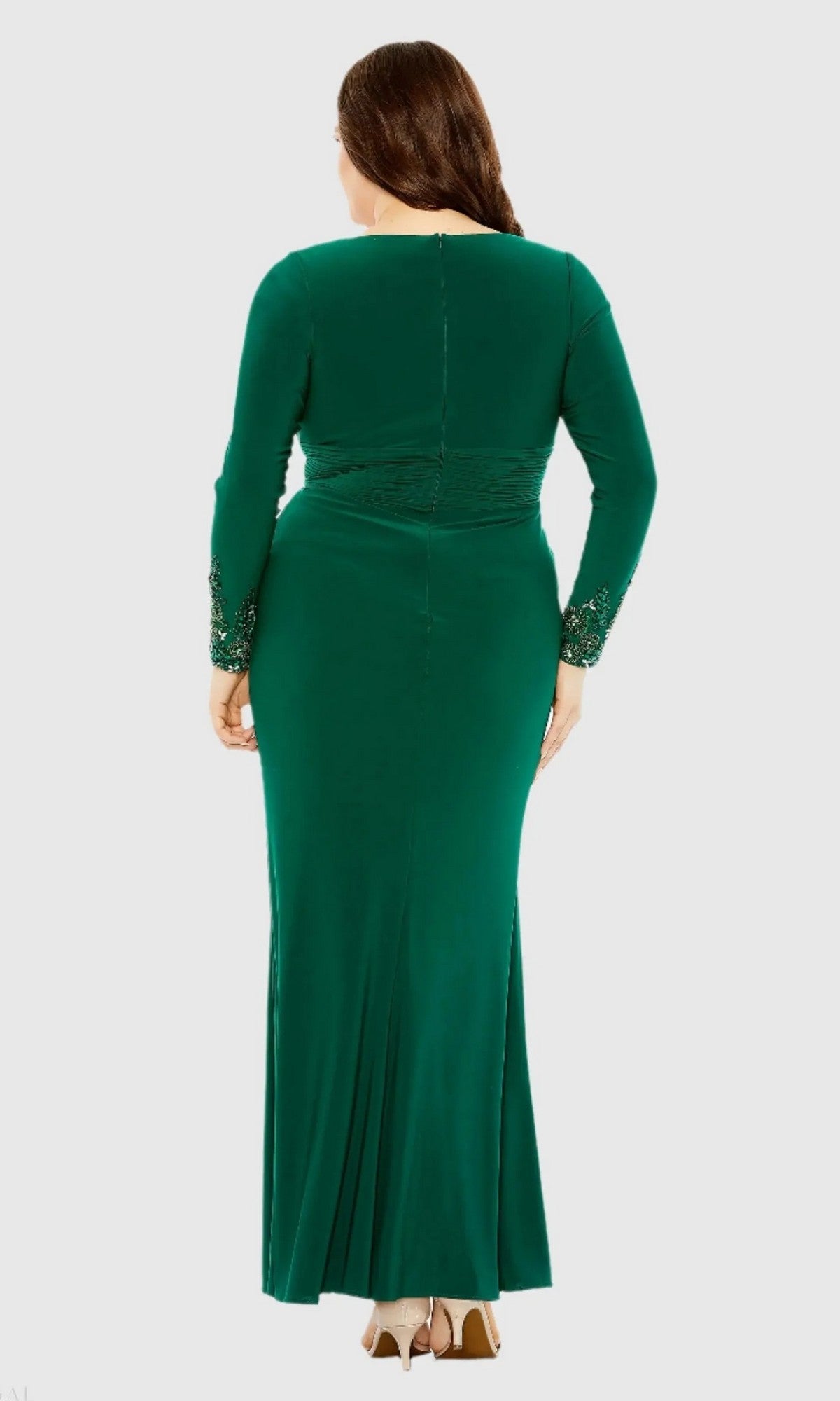 A woman stands with her back to the camera against a plain background, wearing the floor-length green Mac Duggal 77024 Long Plus-Size Formal Dress, which features long sleeves with lace-detailed cuffs and radiates timeless elegance.