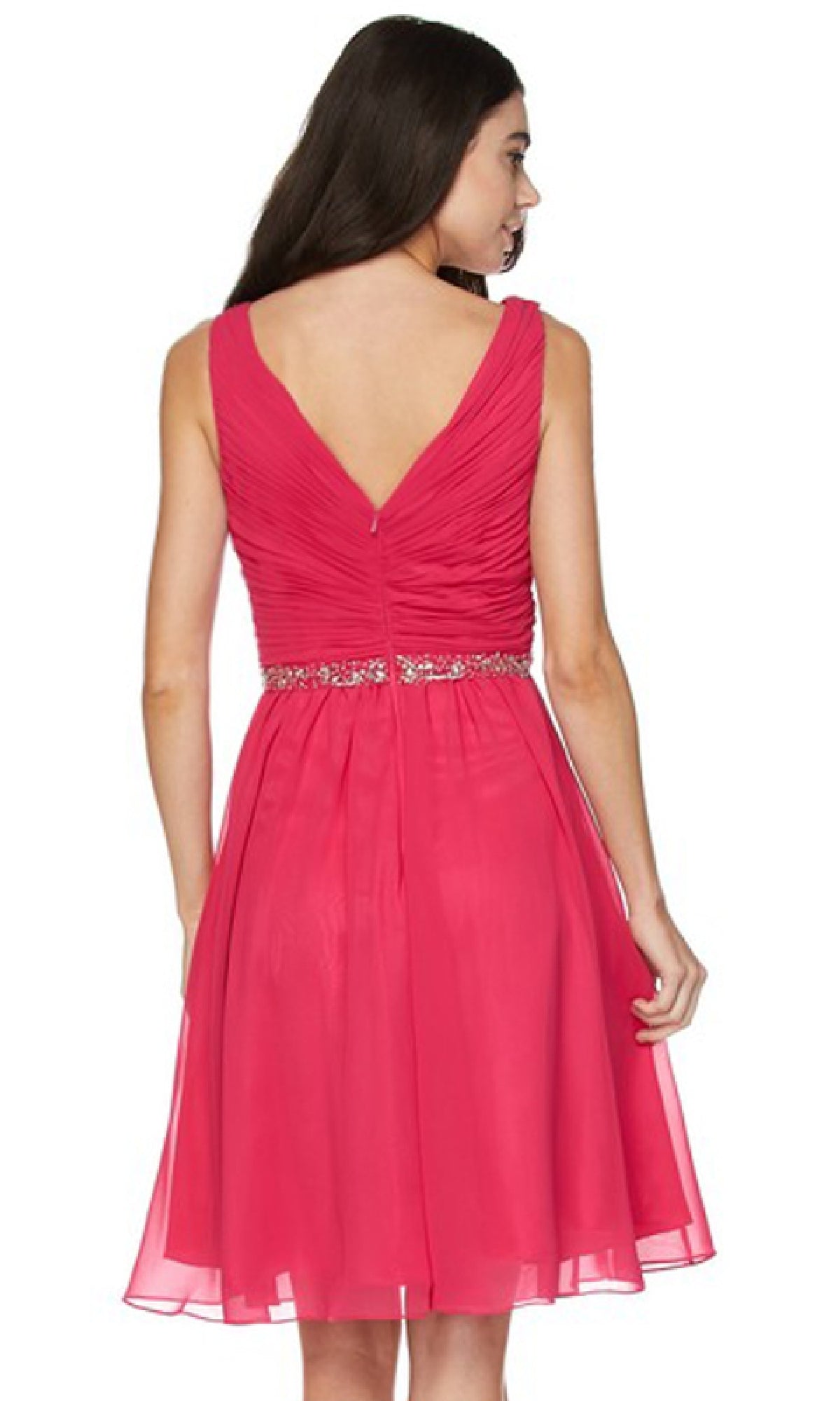 A woman models the Juliet 786 short semi-formal dress, featuring a sleeveless pink A-line design with a beaded empire waist and V-back, standing and facing away from the camera.