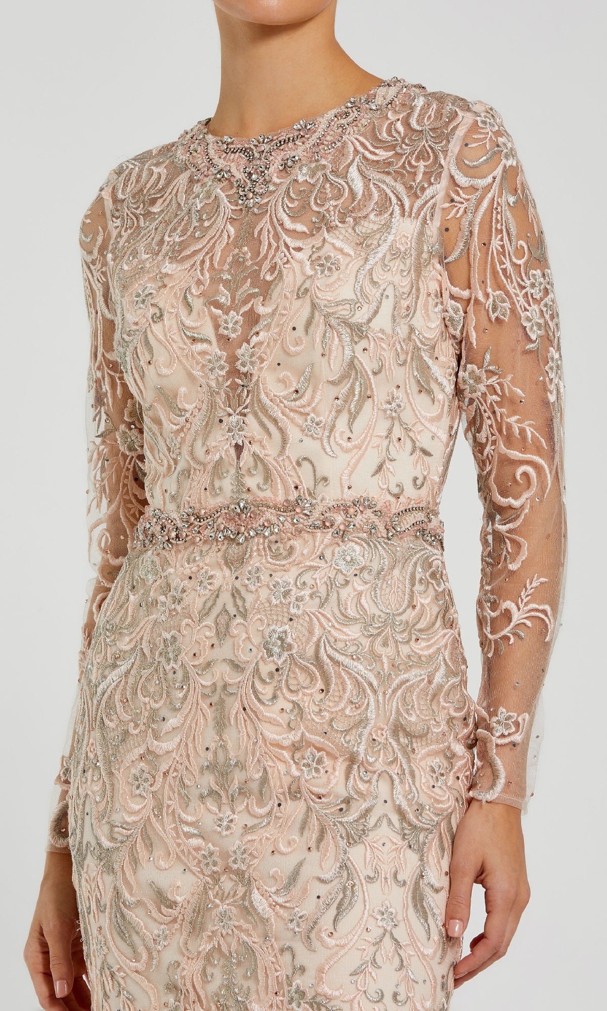 Woman wearing the Beaded Long Pink Formal Dress: Mac Duggal 79267—a long-sleeve gown featuring nude tones, sheer detailing, and intricate silver and pink embroidery with beadwork on the bodice and sleeves.