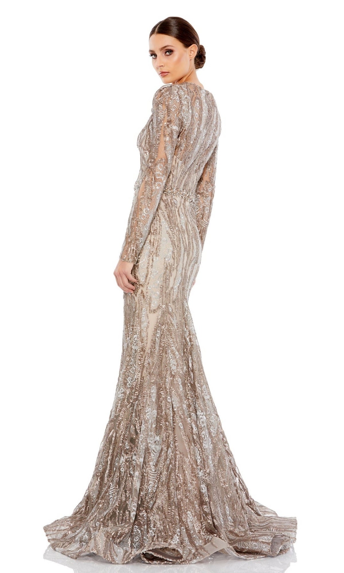 A woman in the Mac Duggal 79358 long taupe beaded formal dress stands turned slightly back, displaying its shimmering beads, full length, and elegant train against a white background.