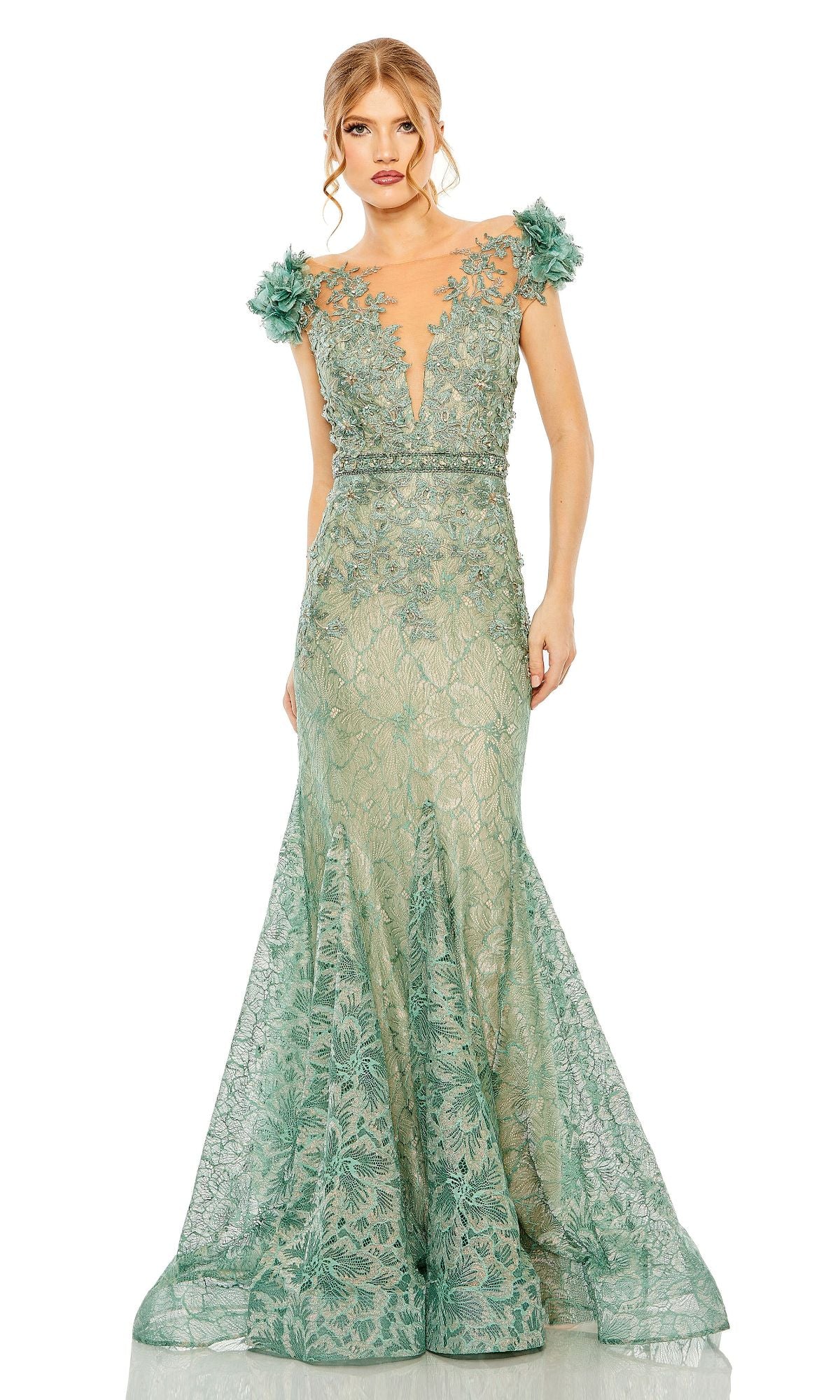 A woman in the Mac Duggal 79368 cap-sleeve long formal dress, featuring light green fabric, floral appliqués on the shoulders, and a deep V-neckline, stands against a plain white background.