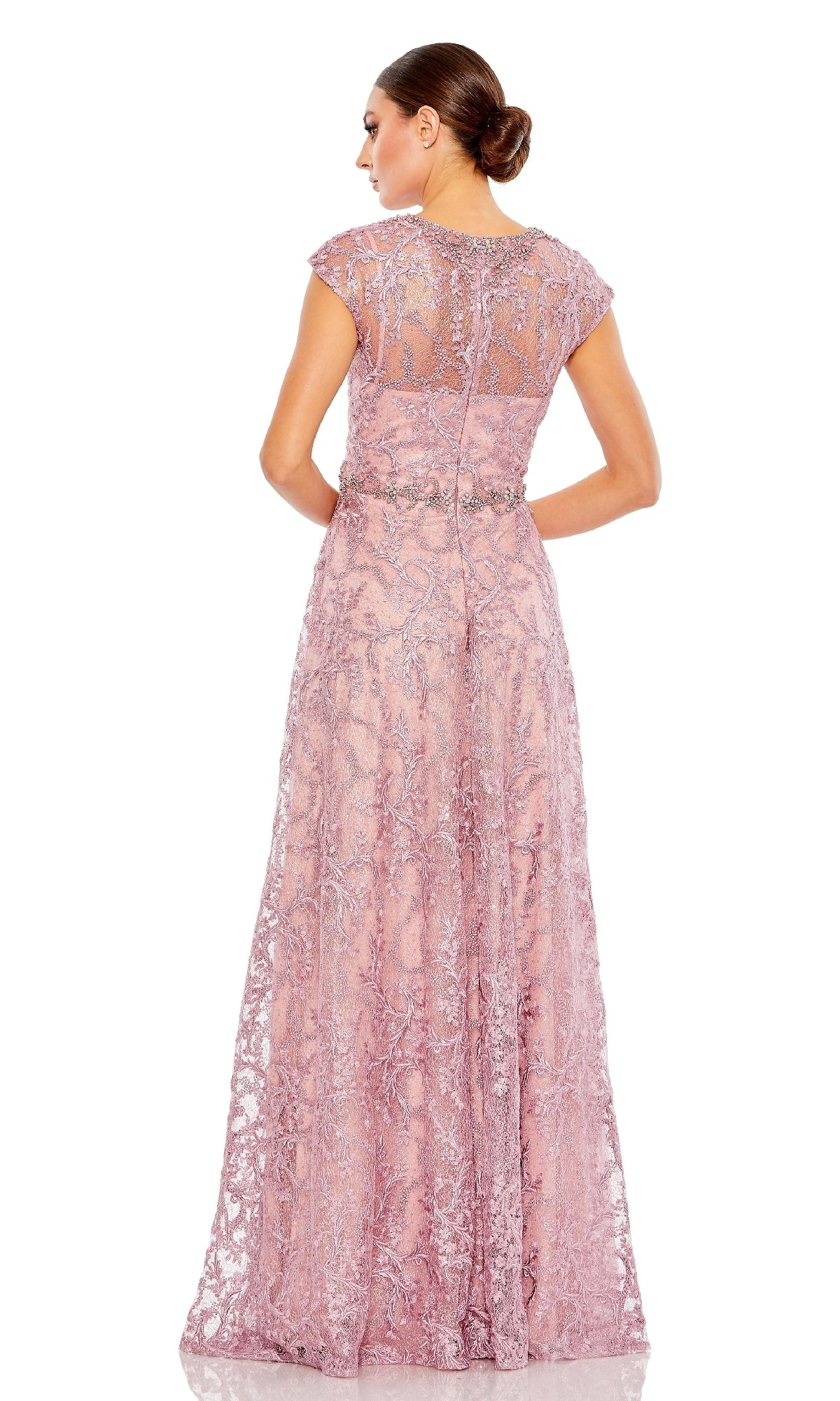 A woman stands with her back to the camera in a floor-length mauve Mac Duggal 79430 beaded-lace formal dress, featuring cap sleeves, a sheer back panel, and intricate detailing.