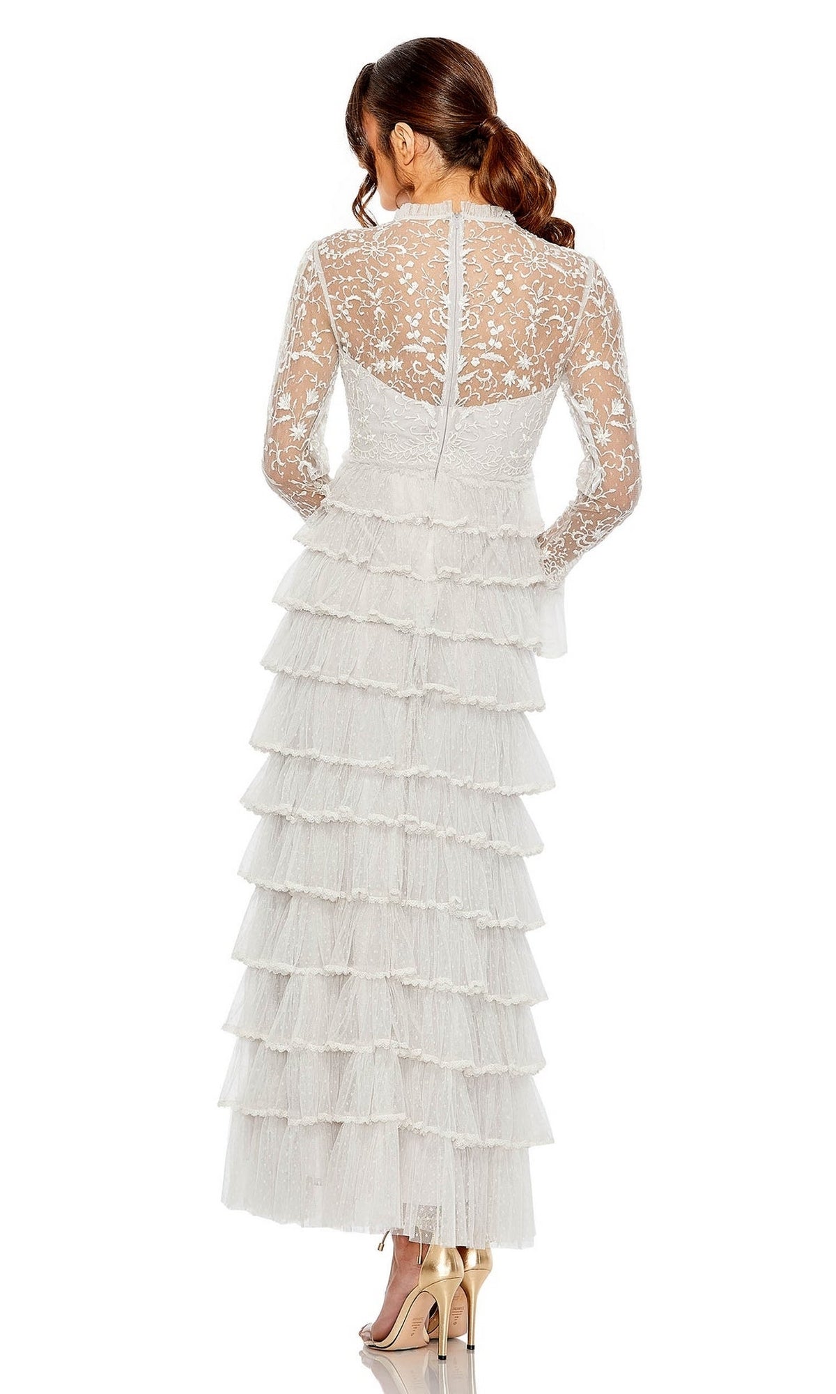 A woman, seen from the back, stands in heels against a plain background wearing the Long Formal Dress 8003 by Mac Duggal—a white lace gown with tiered ruffles and sheer long sleeves.
