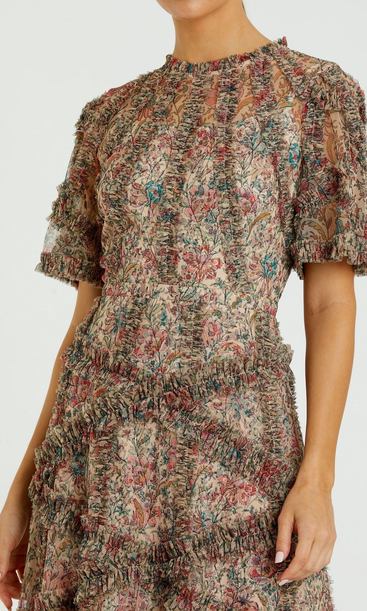 Someone wearing the Mac Duggal 8010 Short-Sleeve Wedding-Guest Dress, which features a tea-length cut, floral print, ruffled detailing, and sheer fabric on the upper chest and sleeves.