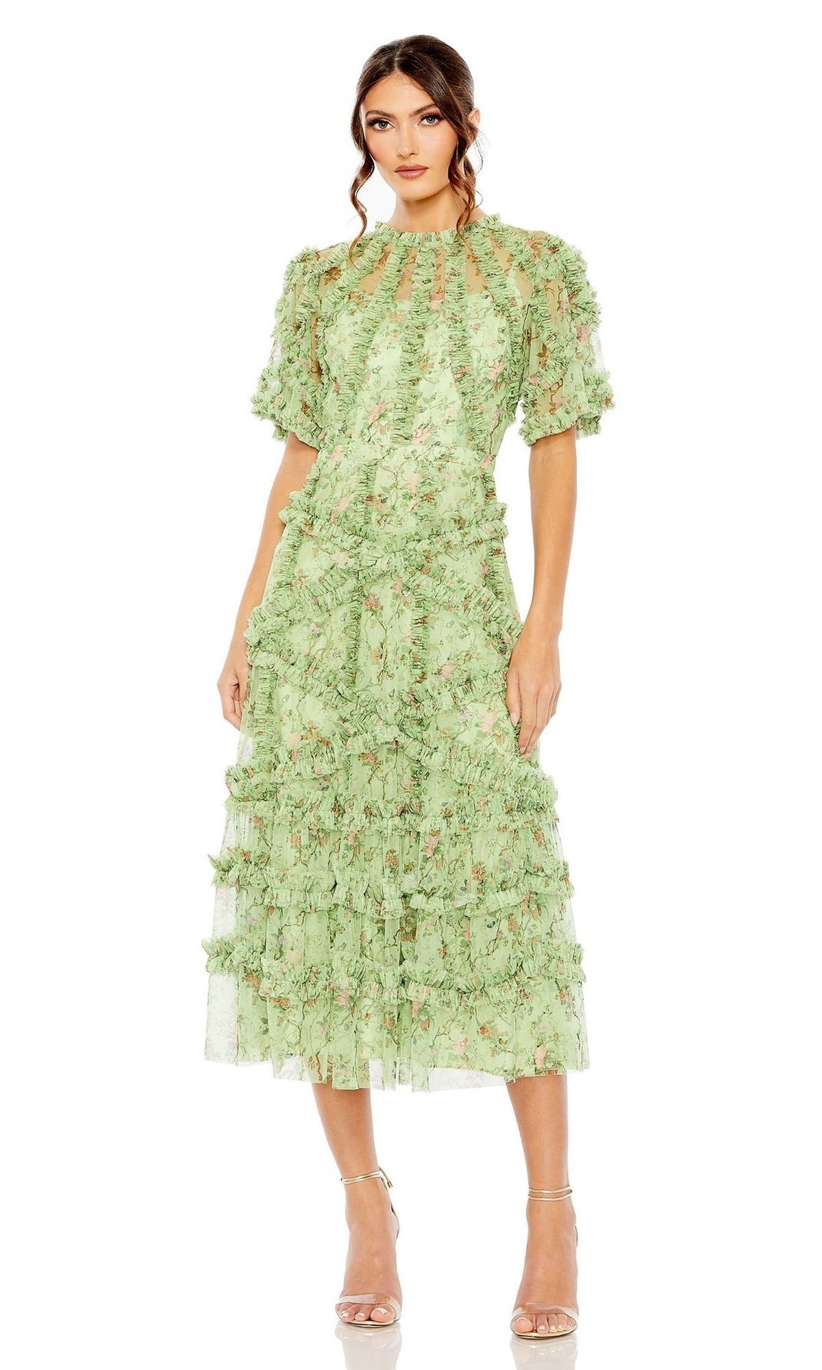 A woman wears the Mac Duggal 8010 Short-Sleeve Wedding-Guest Dress in light green floral print with ruffled details and short puff sleeves, paired with strappy nude heels.