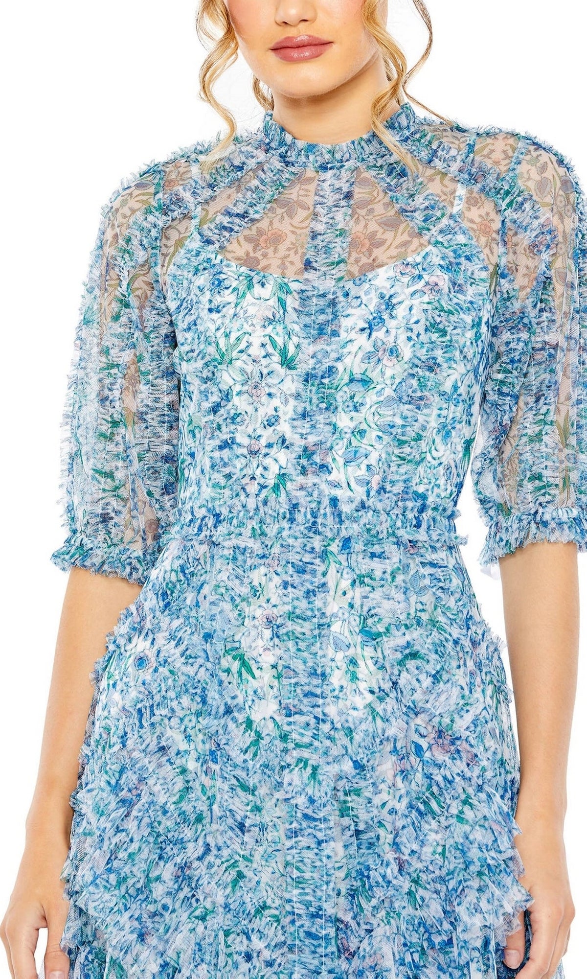A woman wears the Midi Wedding Guest Dress 8011 by Mac Duggal, featuring blue and white florals, sheer puff sleeves, and textured fabric, shown from shoulders to mid-thigh against a white background.
