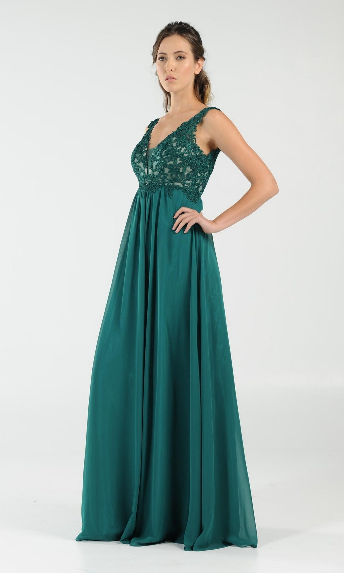 A woman stands against a plain white background wearing the Sleeveless V-Neck Chiffon Long Prom Dress 8012, featuring a floor-length emerald green design with lace bodice and flowing skirt.