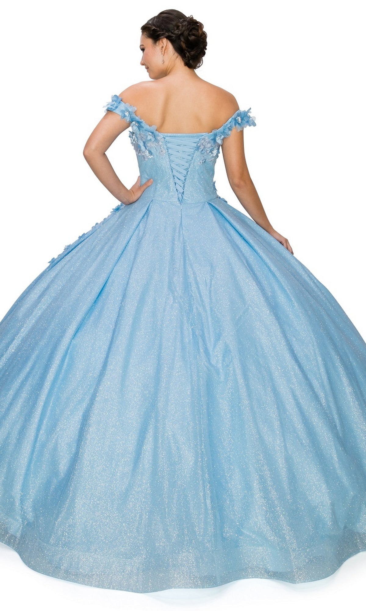 A woman stands with her back to the camera in the Quinceanera Ball Gown 8020J, featuring a sparkly light blue off-the-shoulder design, 3D floral details, laced back, and a glittering full skirt.