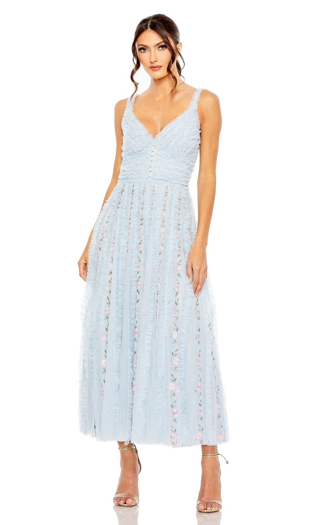 A woman wears the Midi Wedding Guest Dress 8027 by Mac Duggal, a pastel blue sleeveless V-neck A-line midi dress with delicate textured details and sheer pleats, styled with nude high-heeled sandals against a white background.