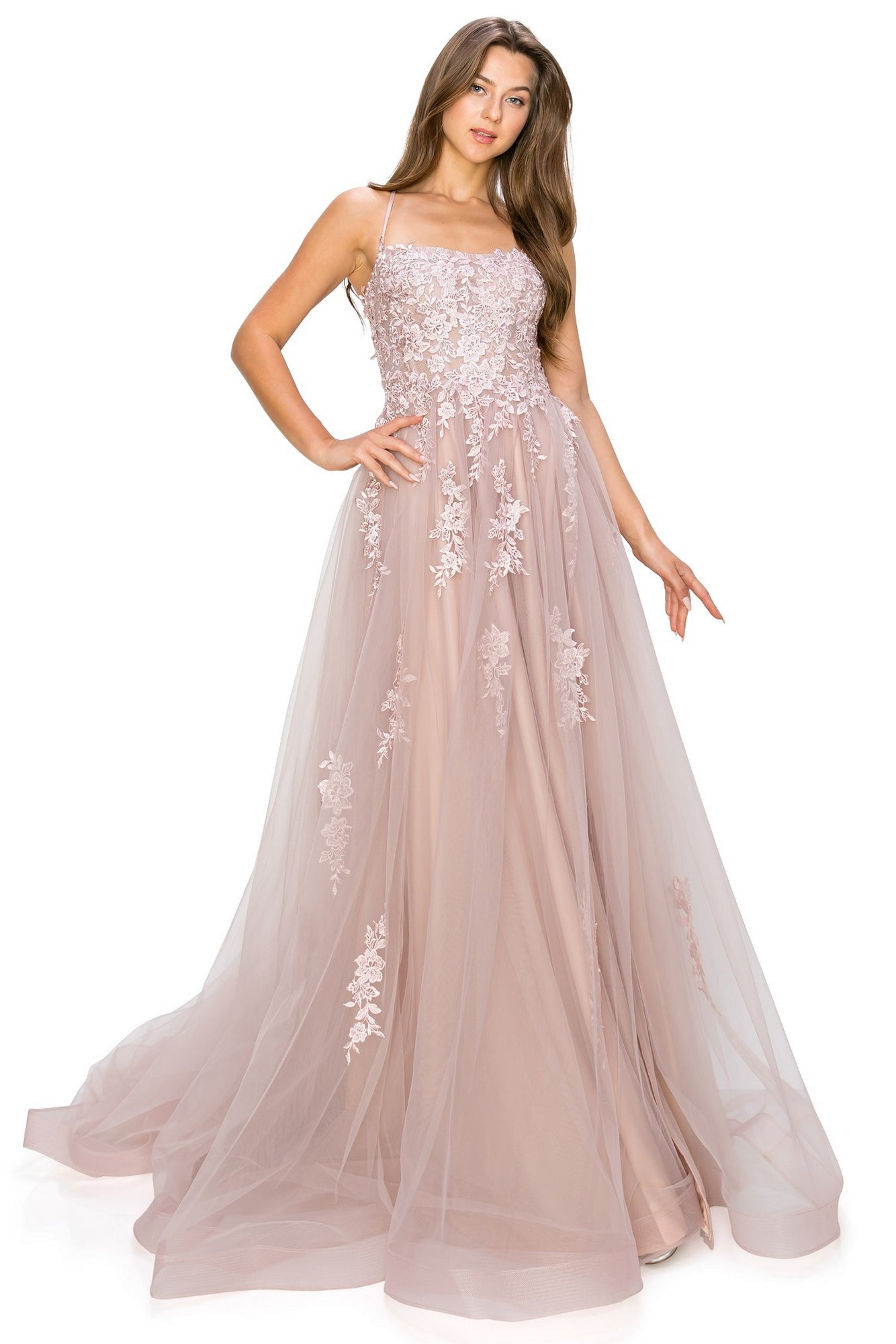 A woman stands with one hand on her hip, wearing the Floral-Embroidered Long Tulle Prom Dress 8031J—a blush pink, floor-length gown with floral embroidery and lace appliqué on the bodice and skirt.