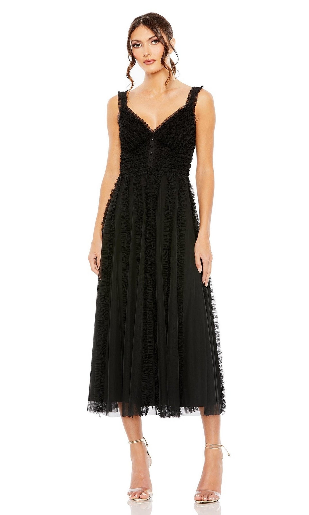 A woman wears the black Mac Duggal 8056 Ruffled Midi Wedding Guest Dress with a sleeveless V-neck, tulle overlay, and ruffle details, styled with strappy heels against a white background—a chic semi-formal party look.