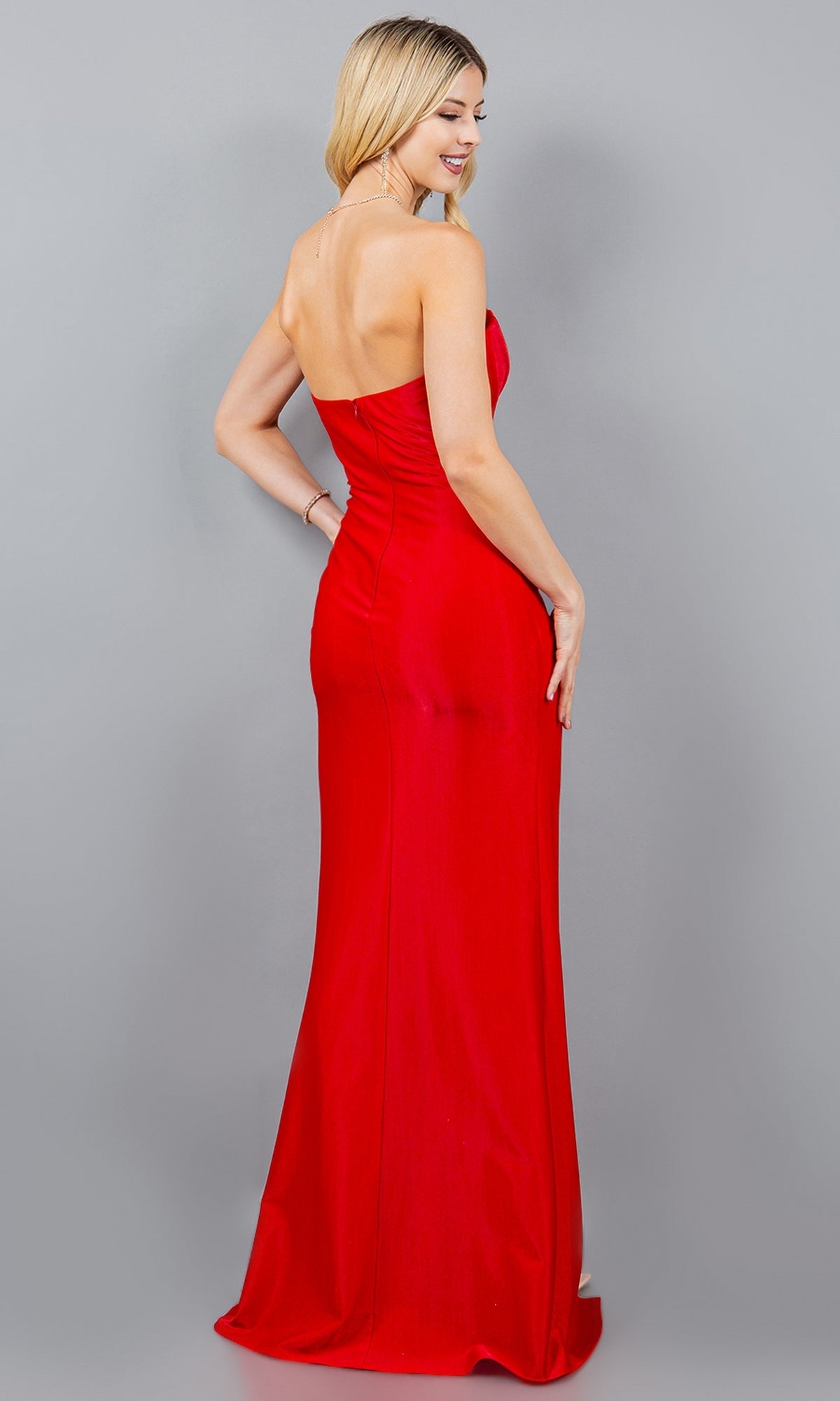 A woman models the Strapless Long Prom Gown, Cinderella Couture 8095J, posing with her back turned and looking over her shoulder against a plain gray background.