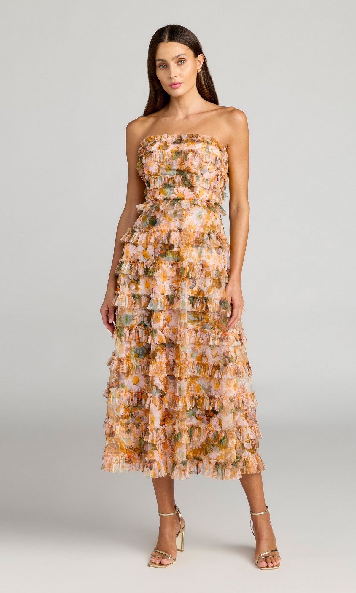 A woman wears the Mac Duggal 8137 Strapless Long Print Formal Dress with layered ruffles, ankle-length hem, and heels—a chic floral-print evening look.