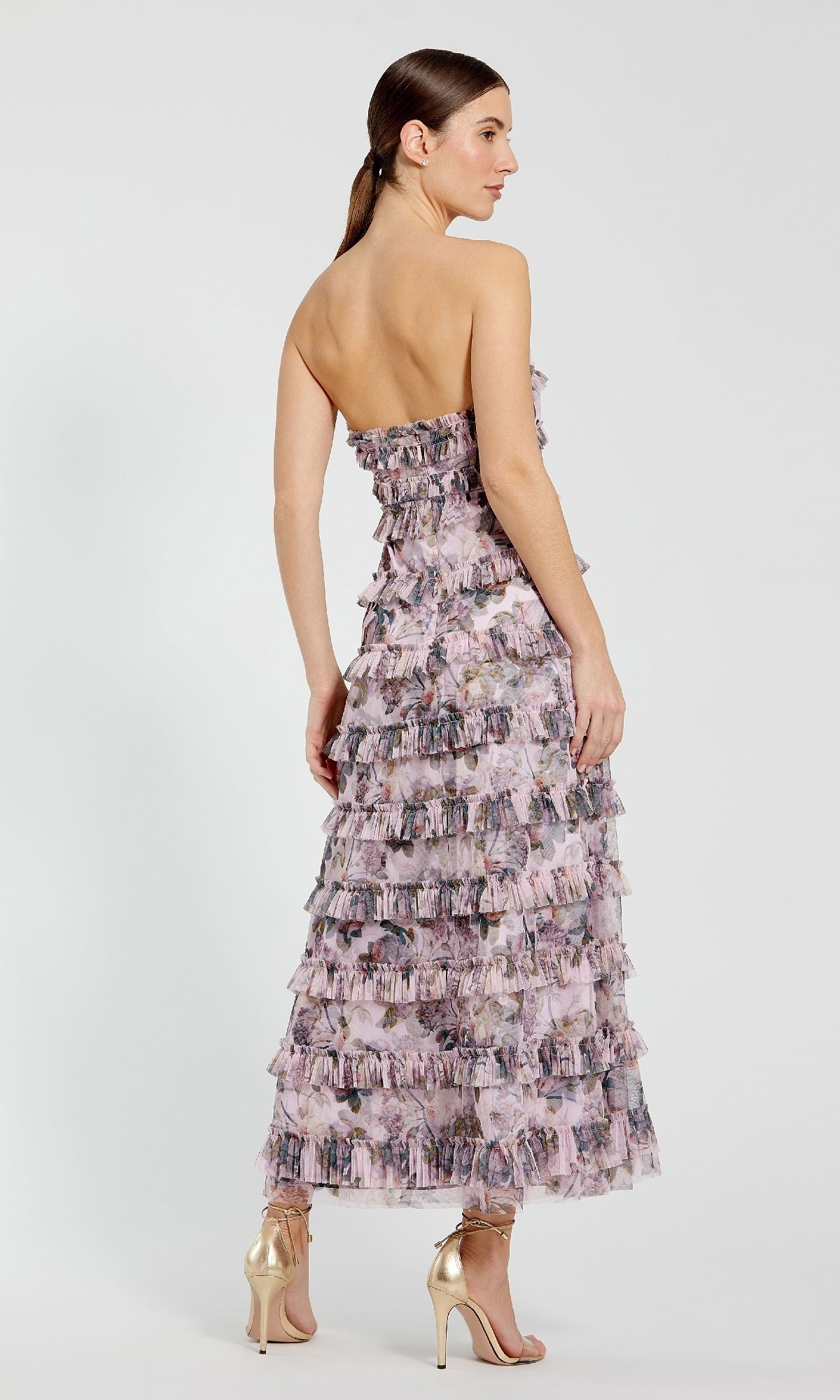 Woman wearing a floral strapless dress on a white background