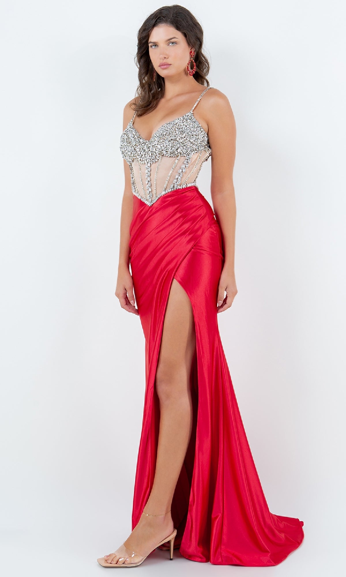 A woman models the Beaded-Bodice Prom Gown by Cinderella Couture 8171J, featuring a red long formal dress with a high slit and fitted beaded sheer bodice, standing against a plain white background.