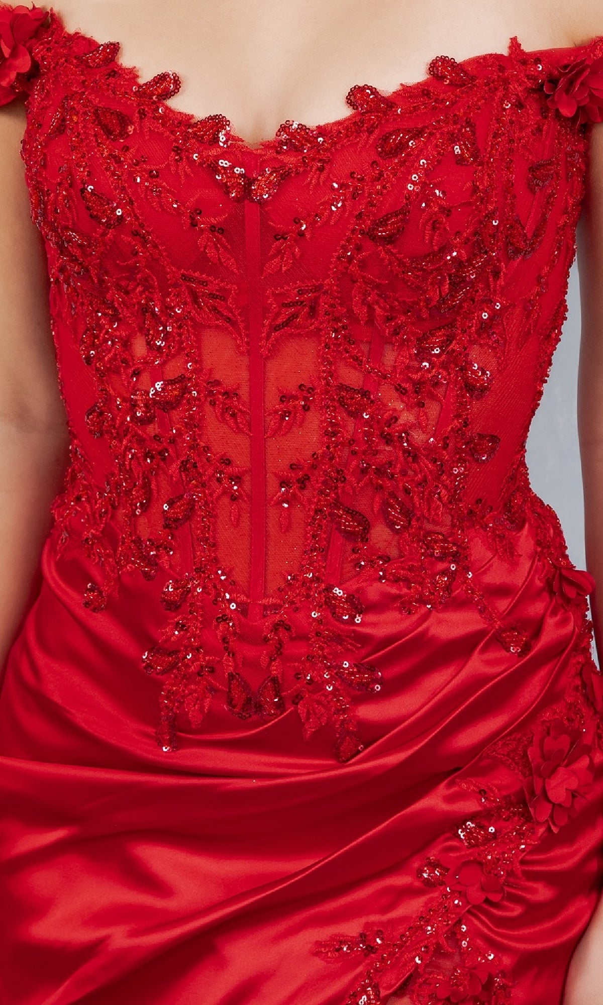 Close-up of a person wearing the Sexy Short Hoco Dress: Cinderella Couture 8181JS, featuring an off-the-shoulder red design with intricate beadwork, sequins, lace detailing, and a sheer corset-style bodice.