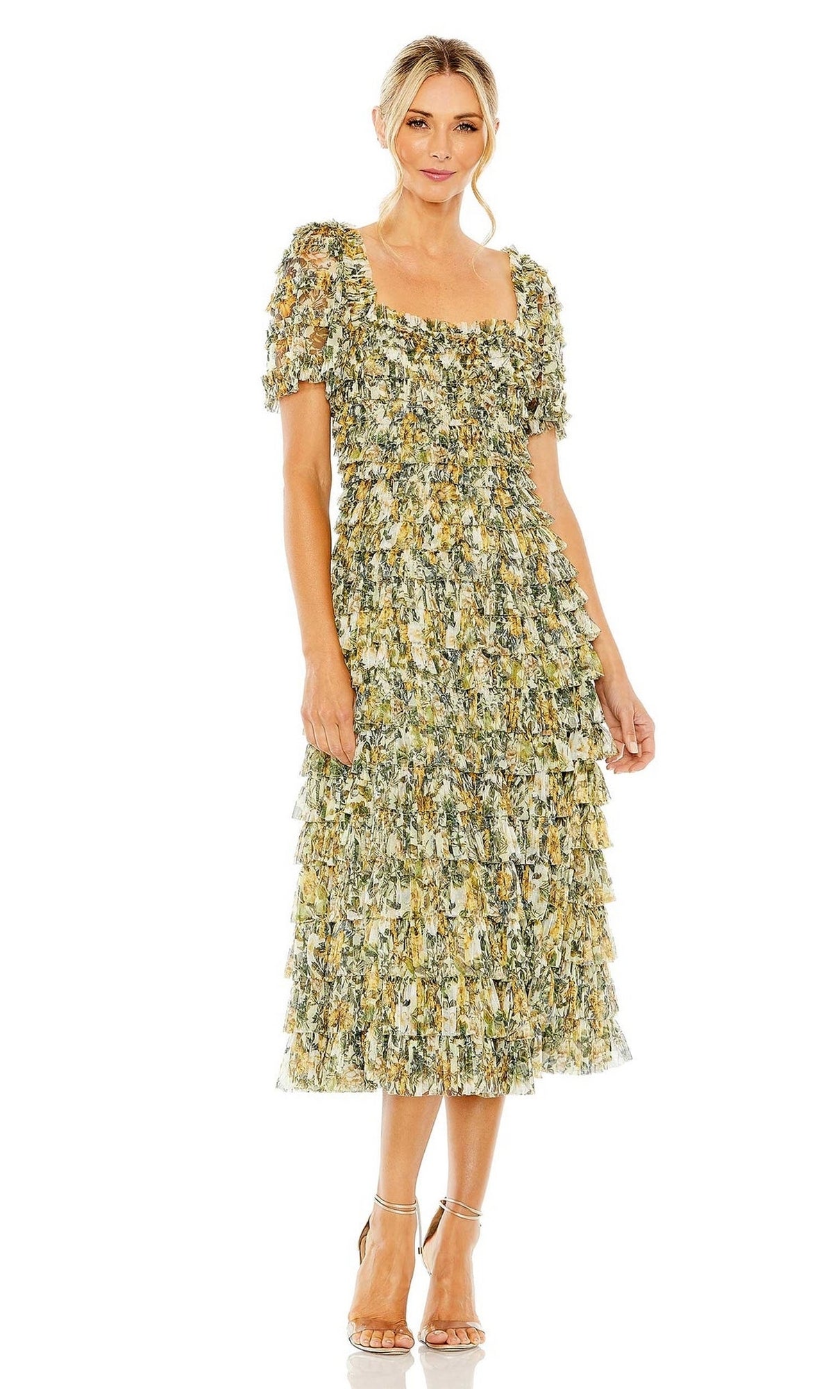 A woman wears the Midi Wedding Guest Dress 8232 by Mac Duggal, a mid-length, short-sleeved, floral tiered dress with ruffle layers and a square neckline, paired with strappy sandals against a plain white background.